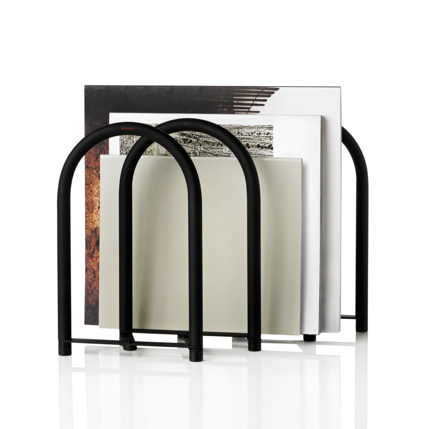 Magazine holder Client: STELTON Location: Denmark Year: 2012 Photo: Stelton MAGZ is a flexible rack for holding magazines, newspapers, letters and books. The folding mechanism makes it easy to adjust the size and capacity. Can be placed on a bookcase, shelf, table or directly on the floor.