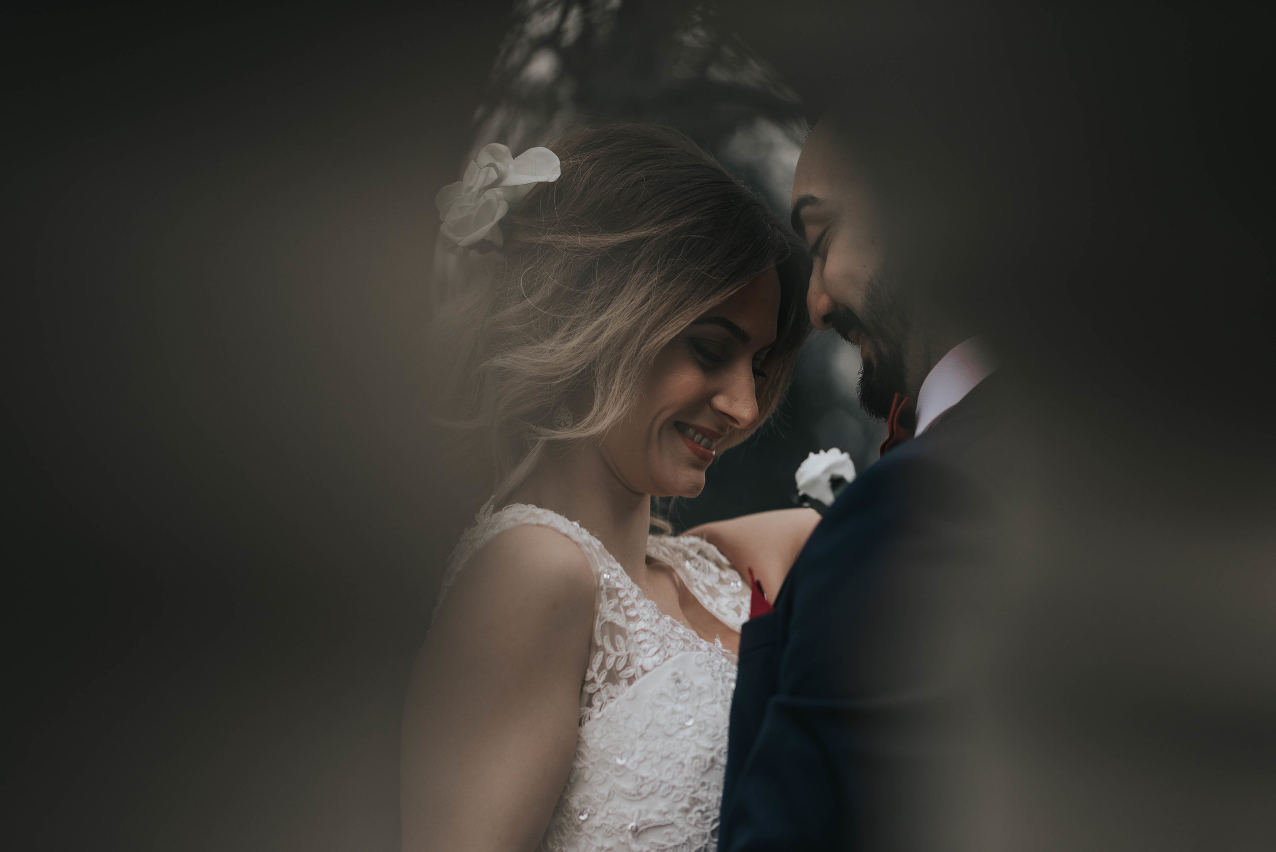 bride and groom have a cheeky giggle together, outside with the soft sunlight lighting their faces