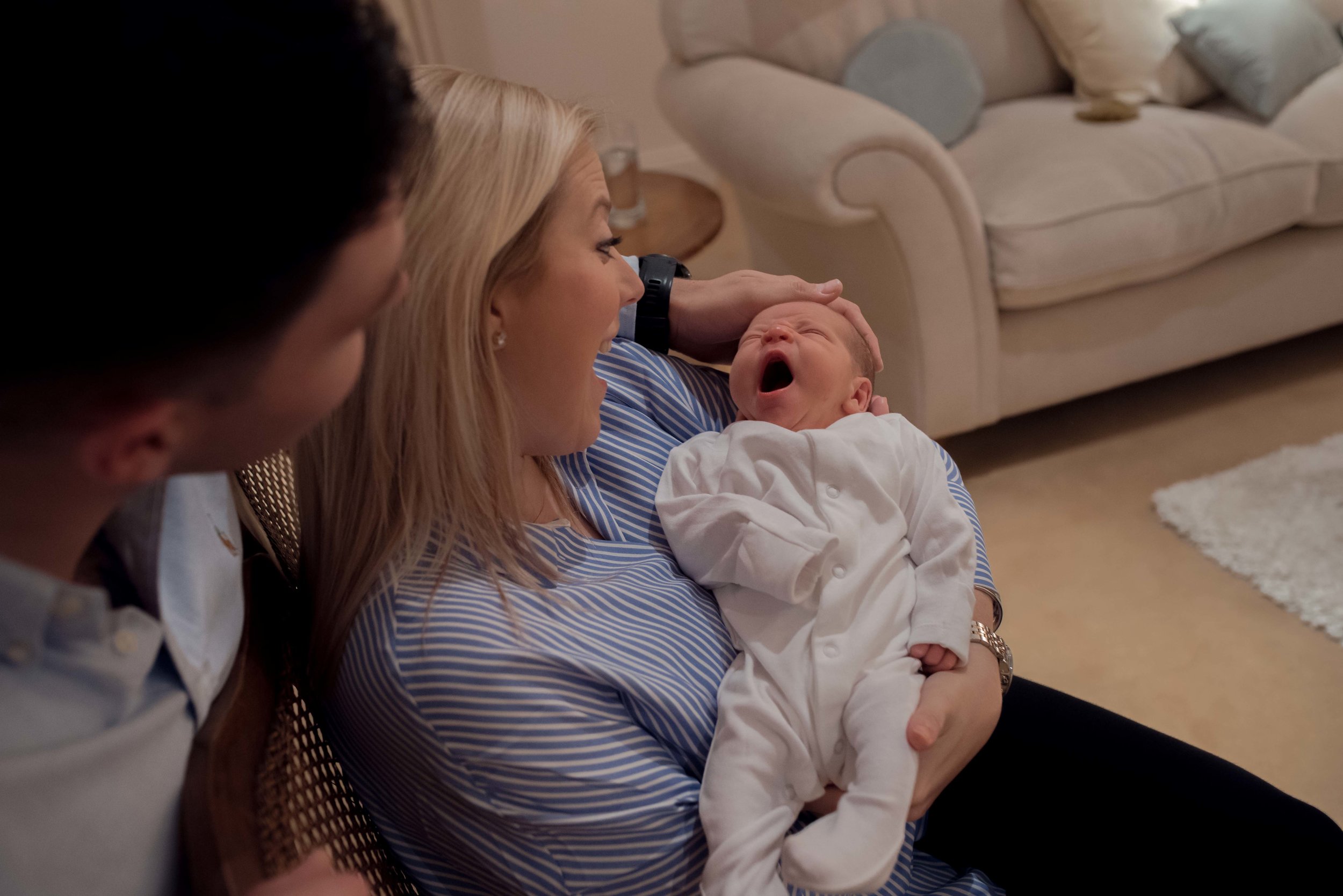 Newborn baby Harry yawn as his mum and dad look lovingly at him.