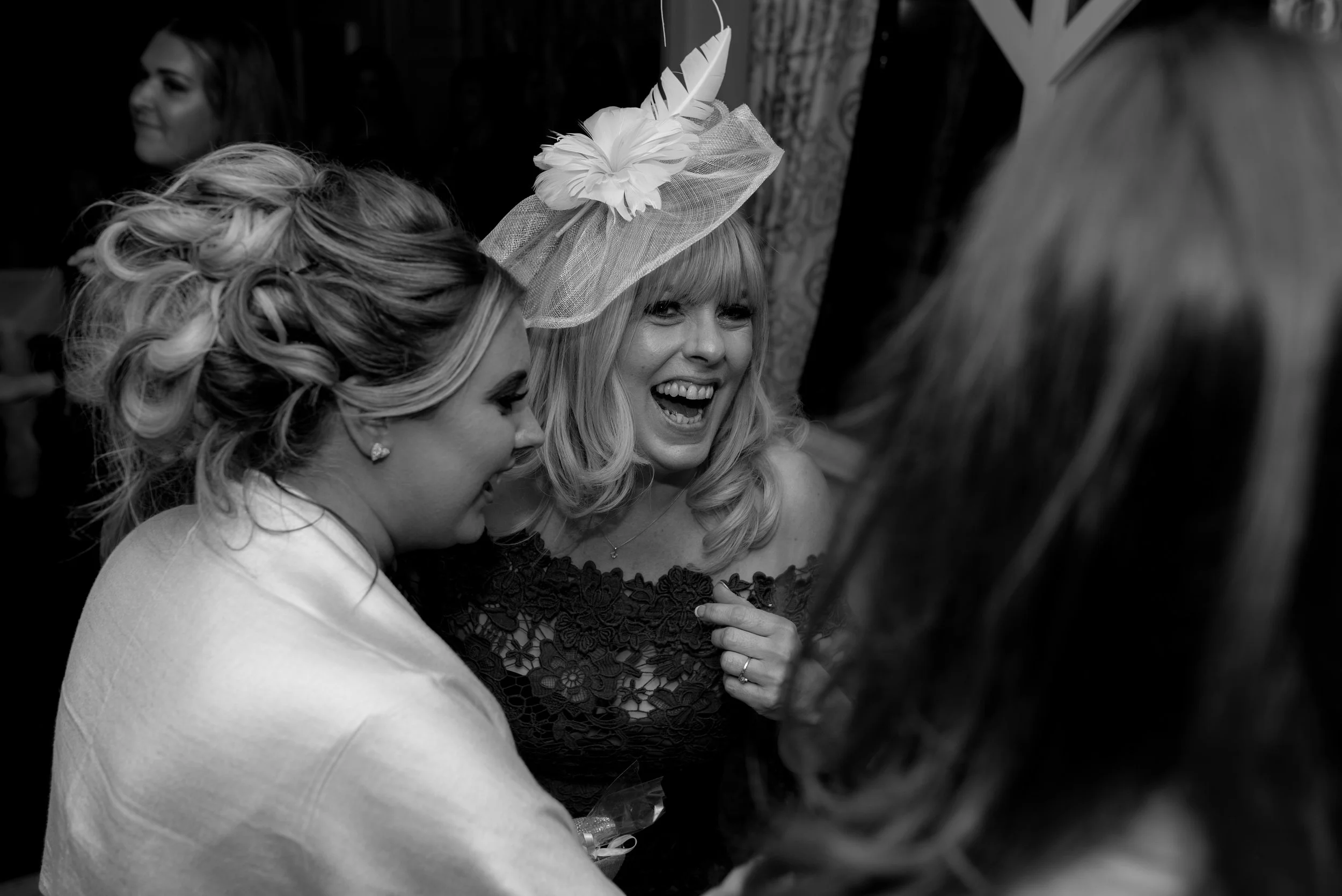 the brides mother has a big laugh with two of her friends on the dance floor