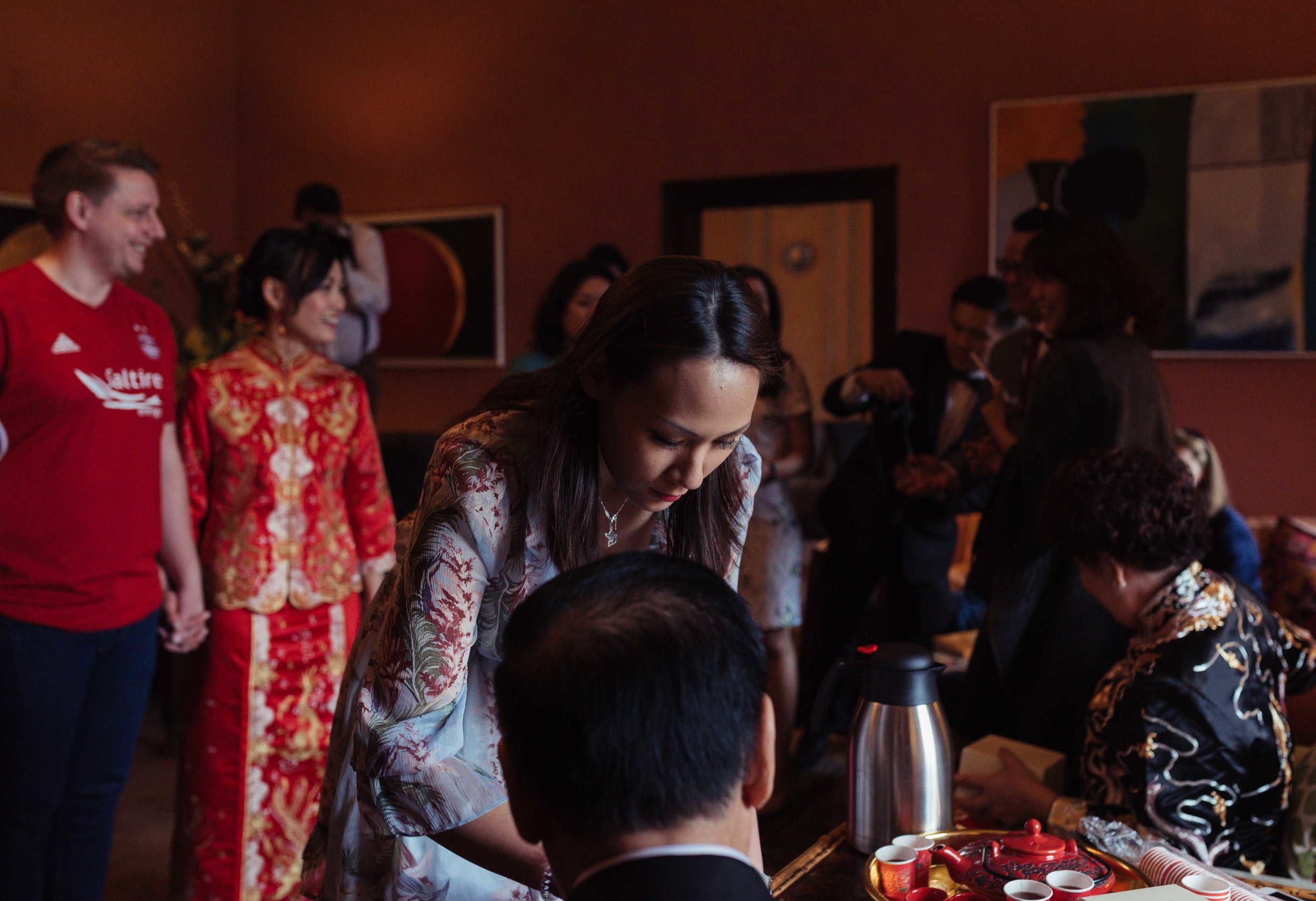 a bridesmaid serves tea at the Chinese tea ceremony