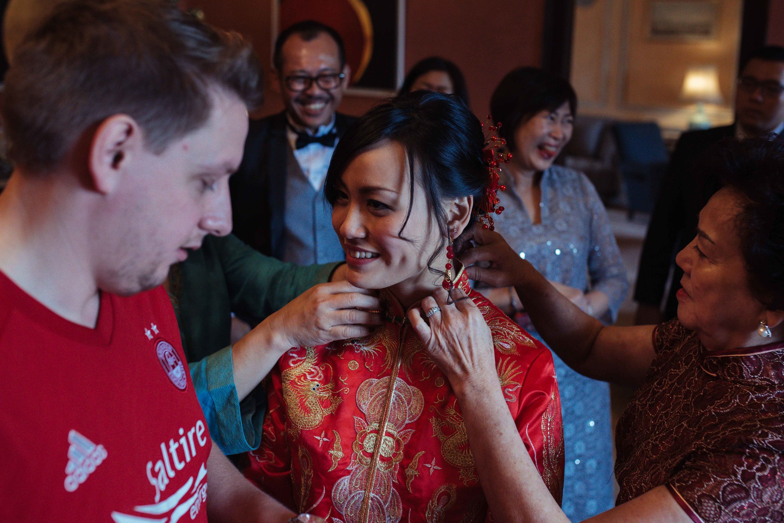 the bride puts on her new earrings during the tea ceremony at Askham Hall