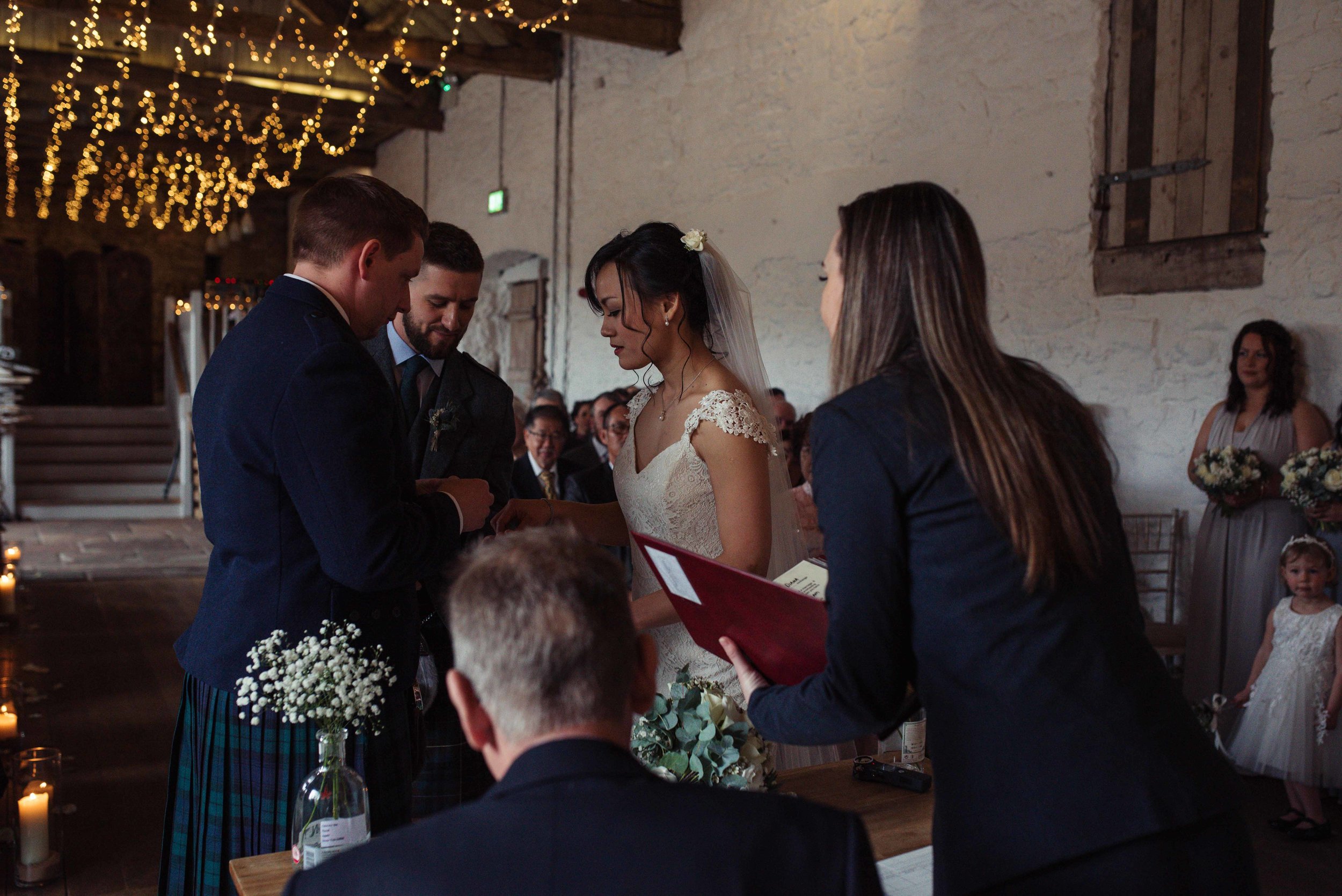 the bride and groom take the rings off the best man during their wedding ceremony