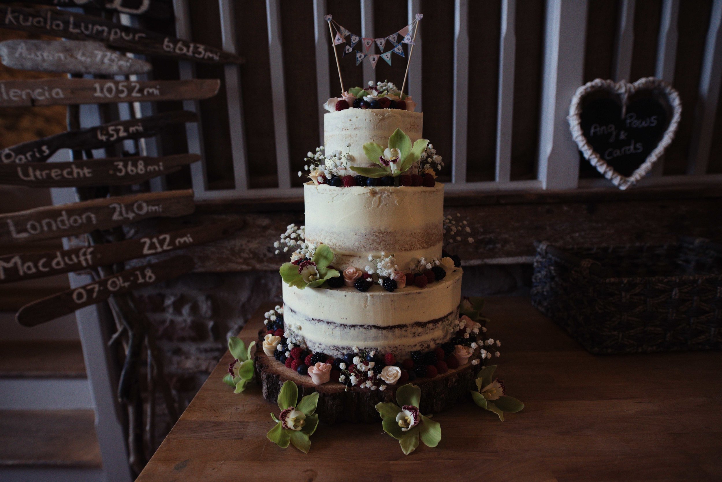 The bride and groom's naked wedding cake, dressed with berries and other fresh fruit