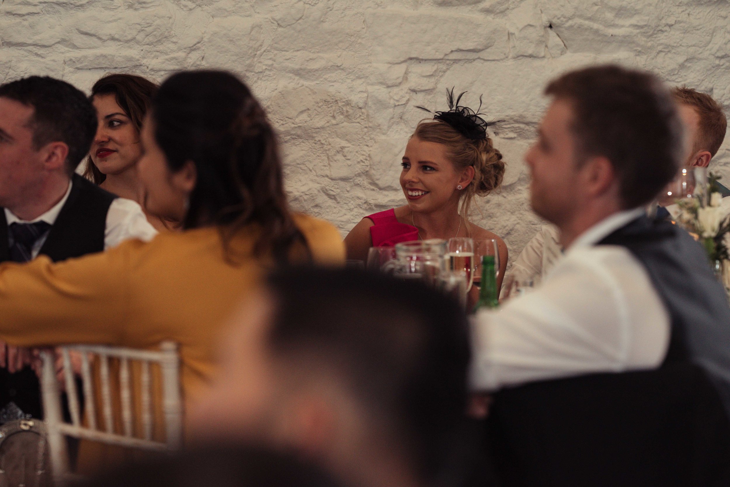 A guest sits during the speeches and has a smile to herself