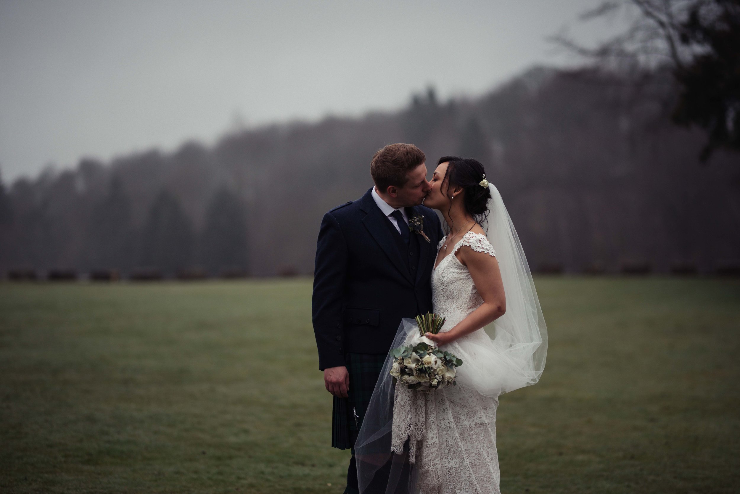 The bride and groom share a kiss together during their wedding photography