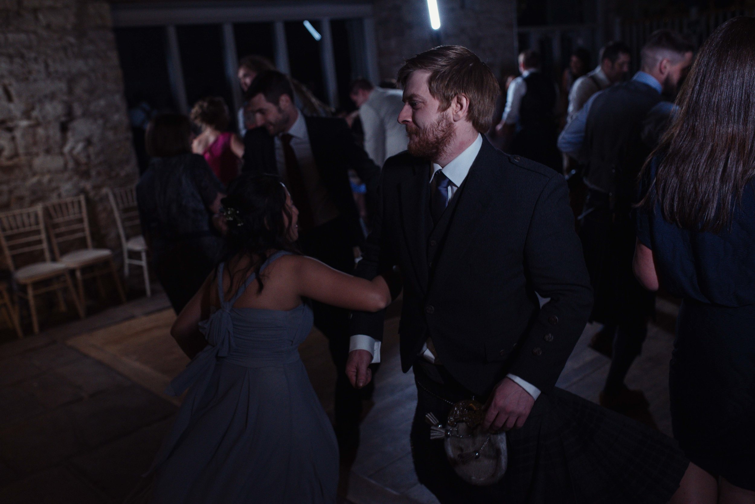 One of the groomsmen is enjoying the scottish dancing on the dance floor