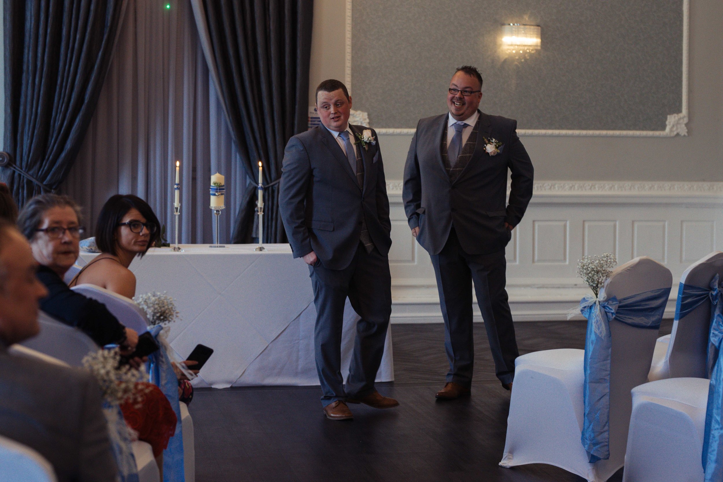 The groom and best man stand at the top of the aisle to wait for the bride.