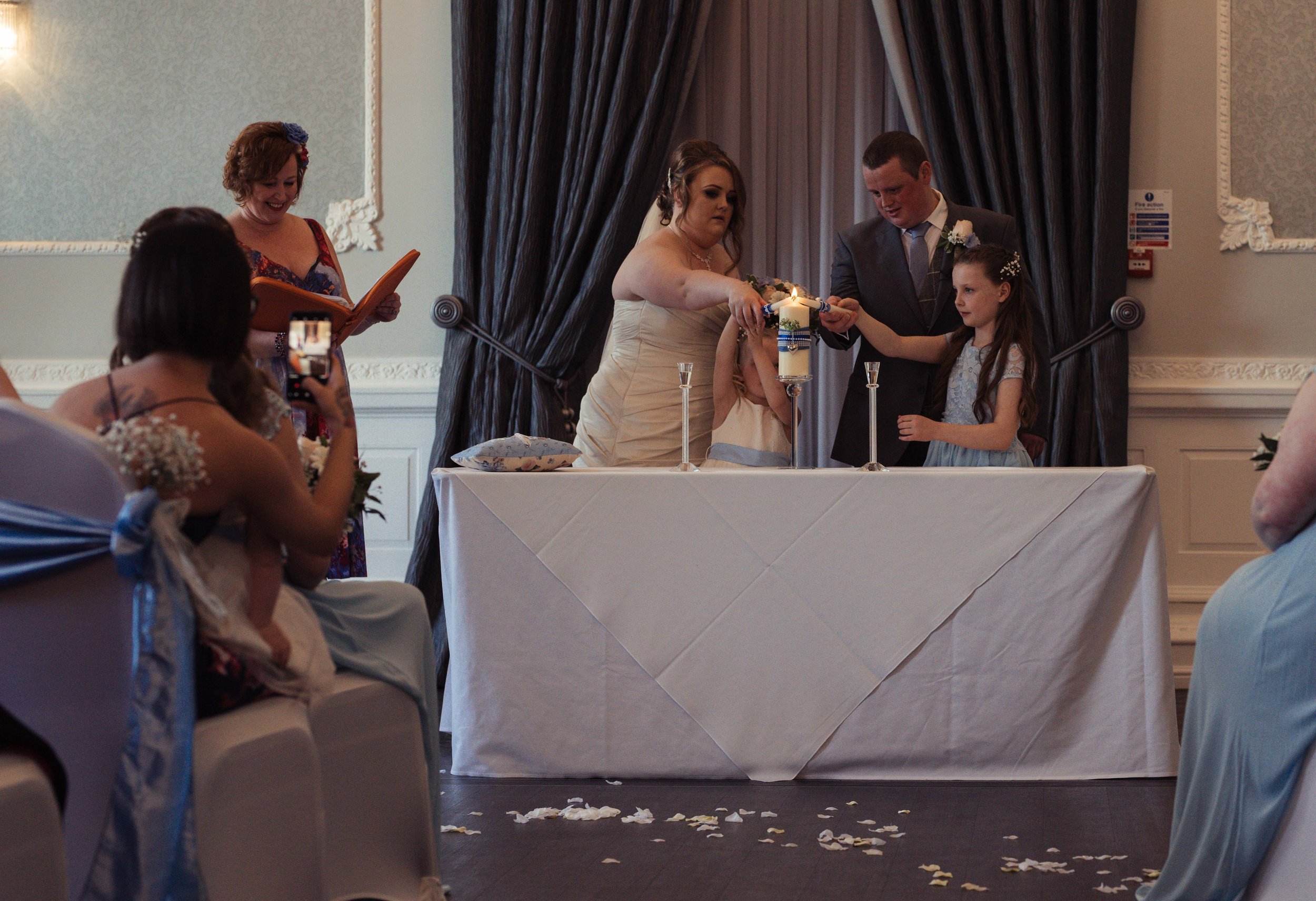 The bride and groom and their two children light candles during the wedding ceremony 