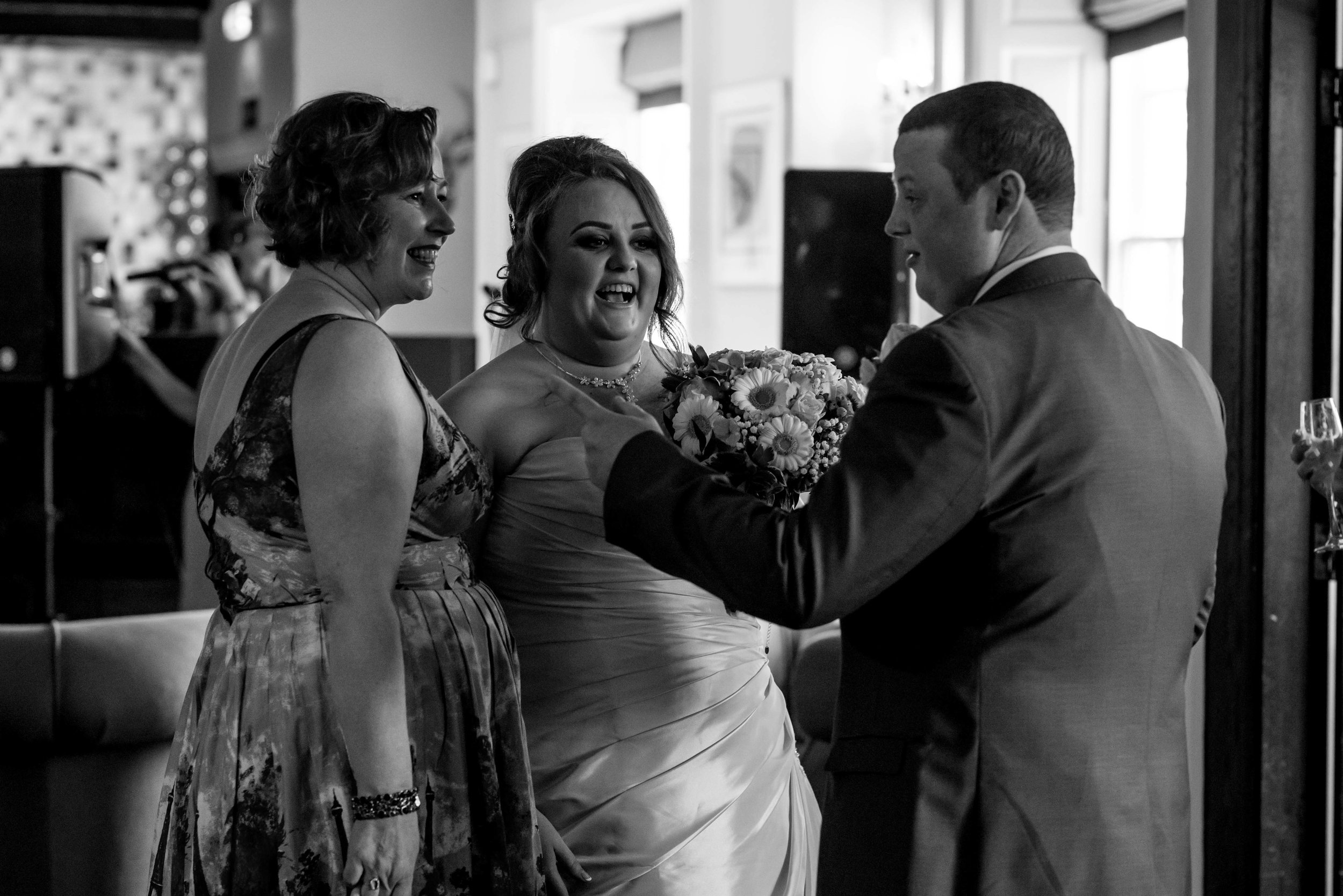 The bride and groom share a laugh with a wedding guest straight after their wedding ceremony