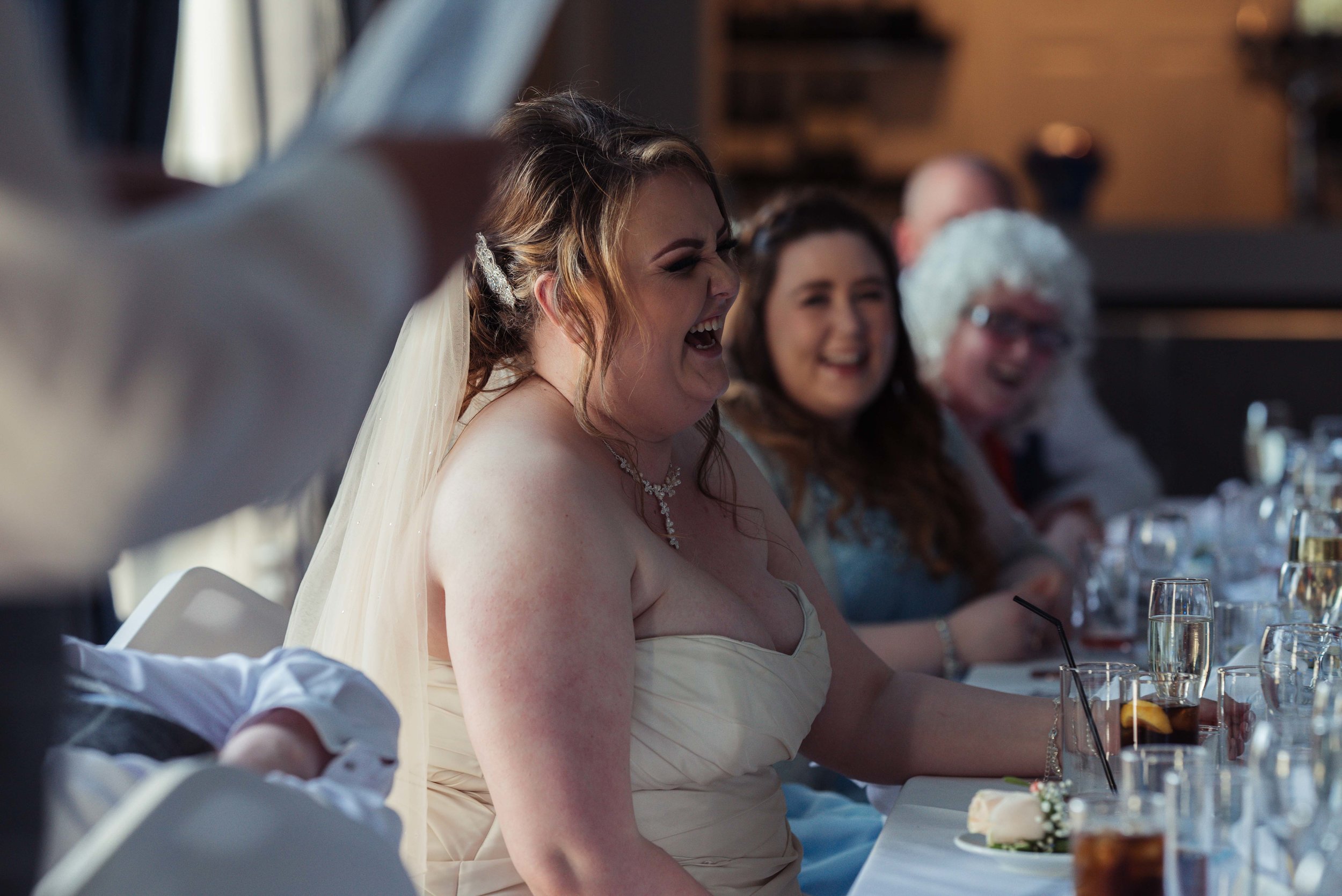 The bride has a huge laugh during one of the wedding soeeches
