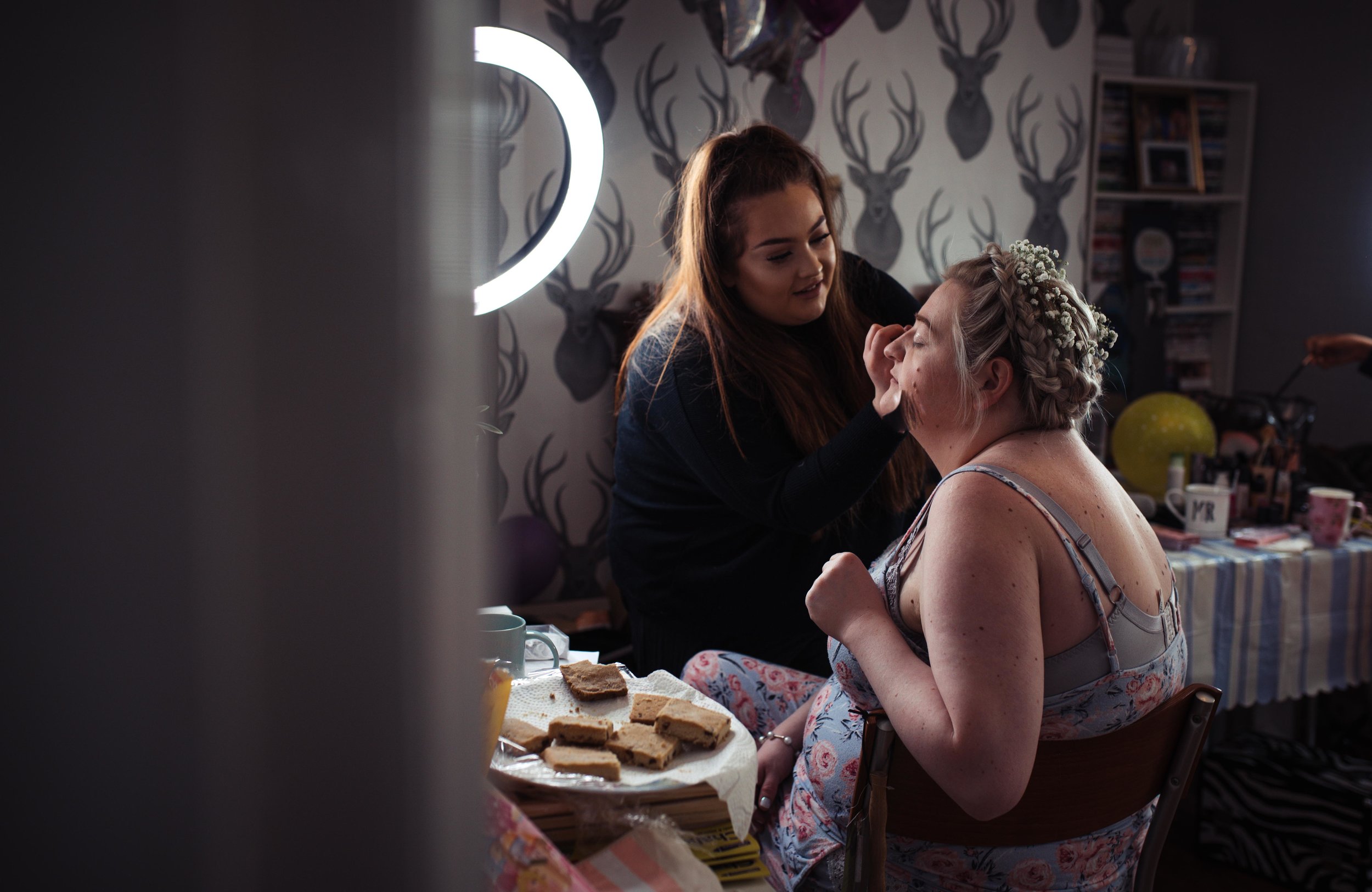 Partially in view bride having her makeup finished