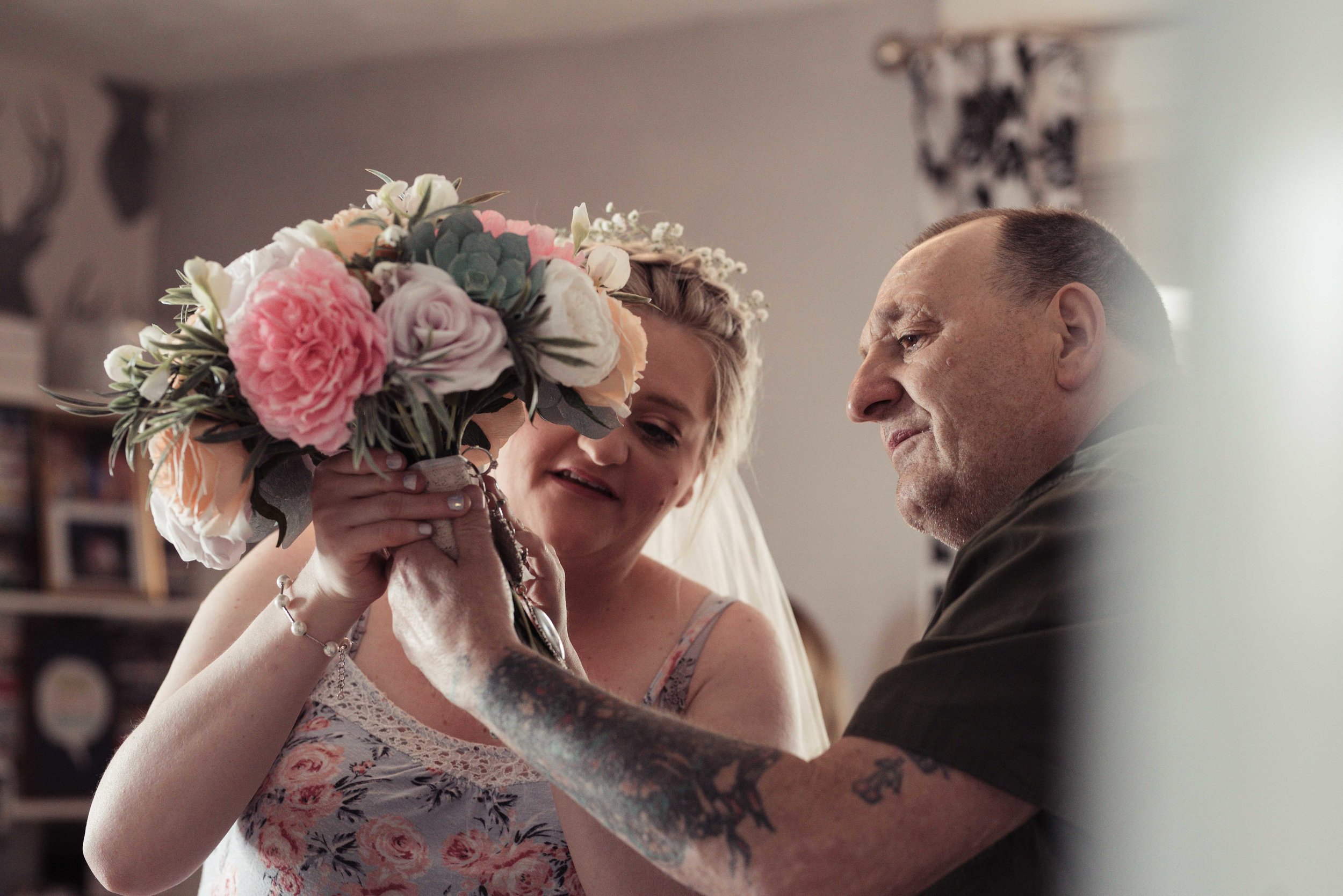 The bride shows her dad her wedding bouquet