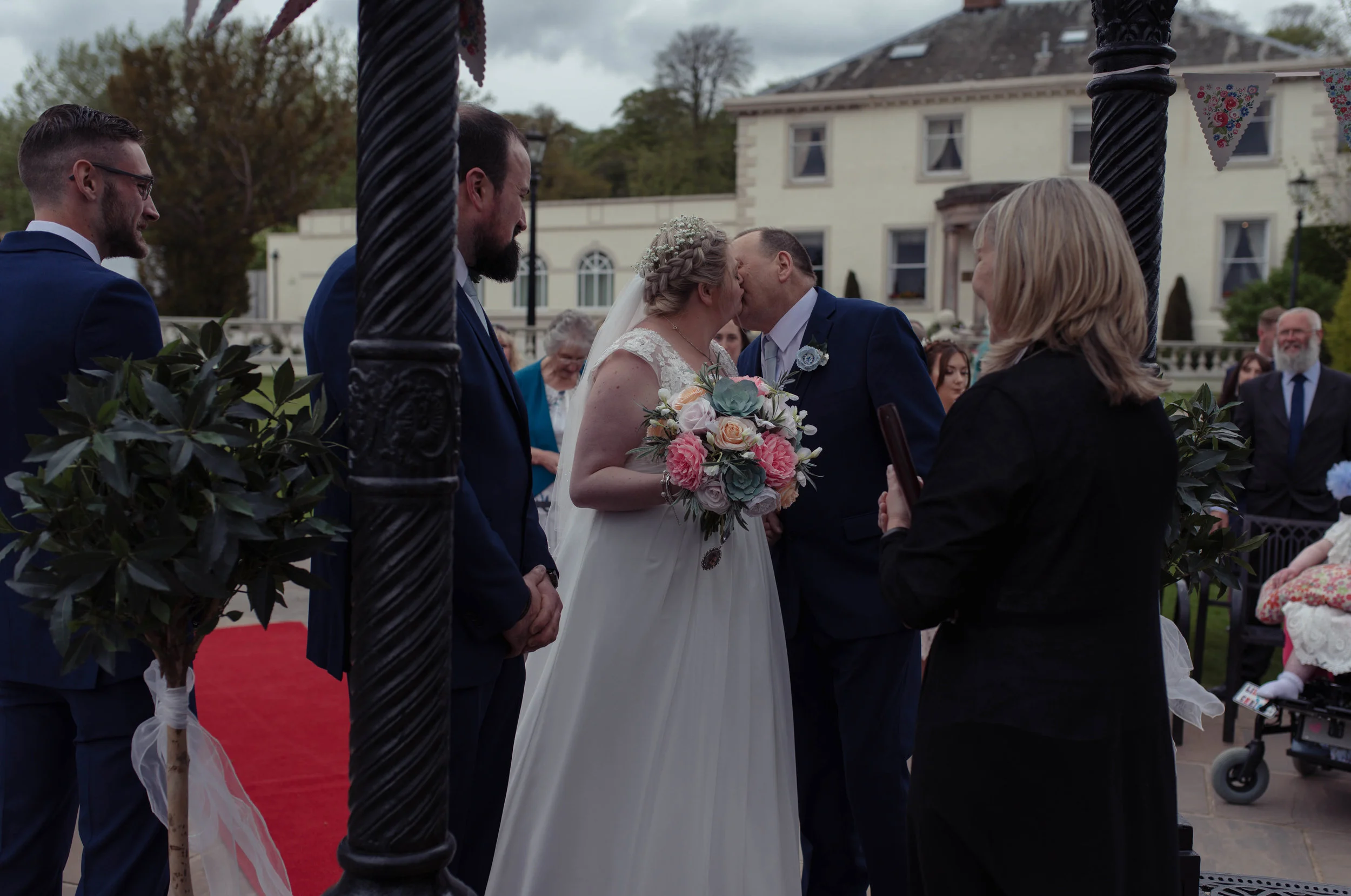 The bride and her father share a kiss as she gives him away