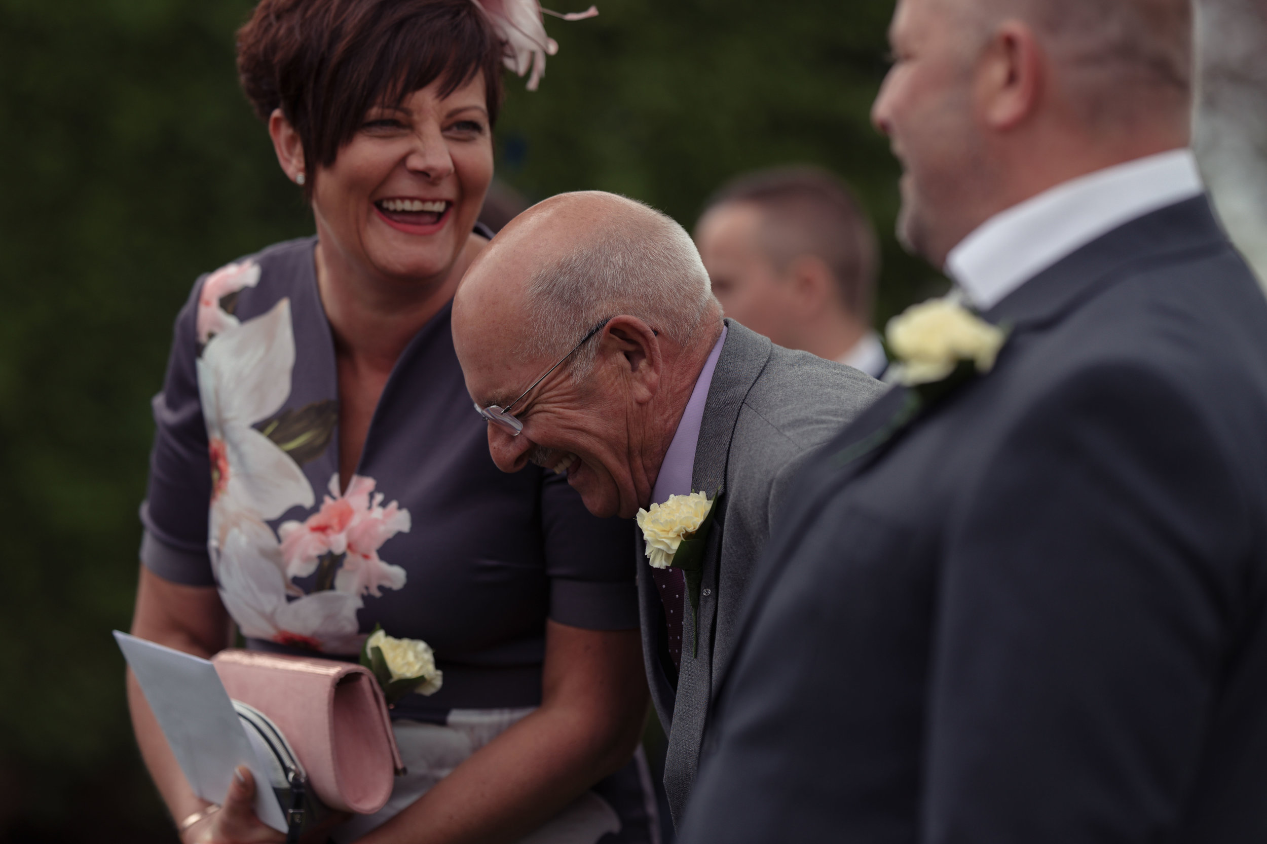 Two wedding guests literally laugh out loud together