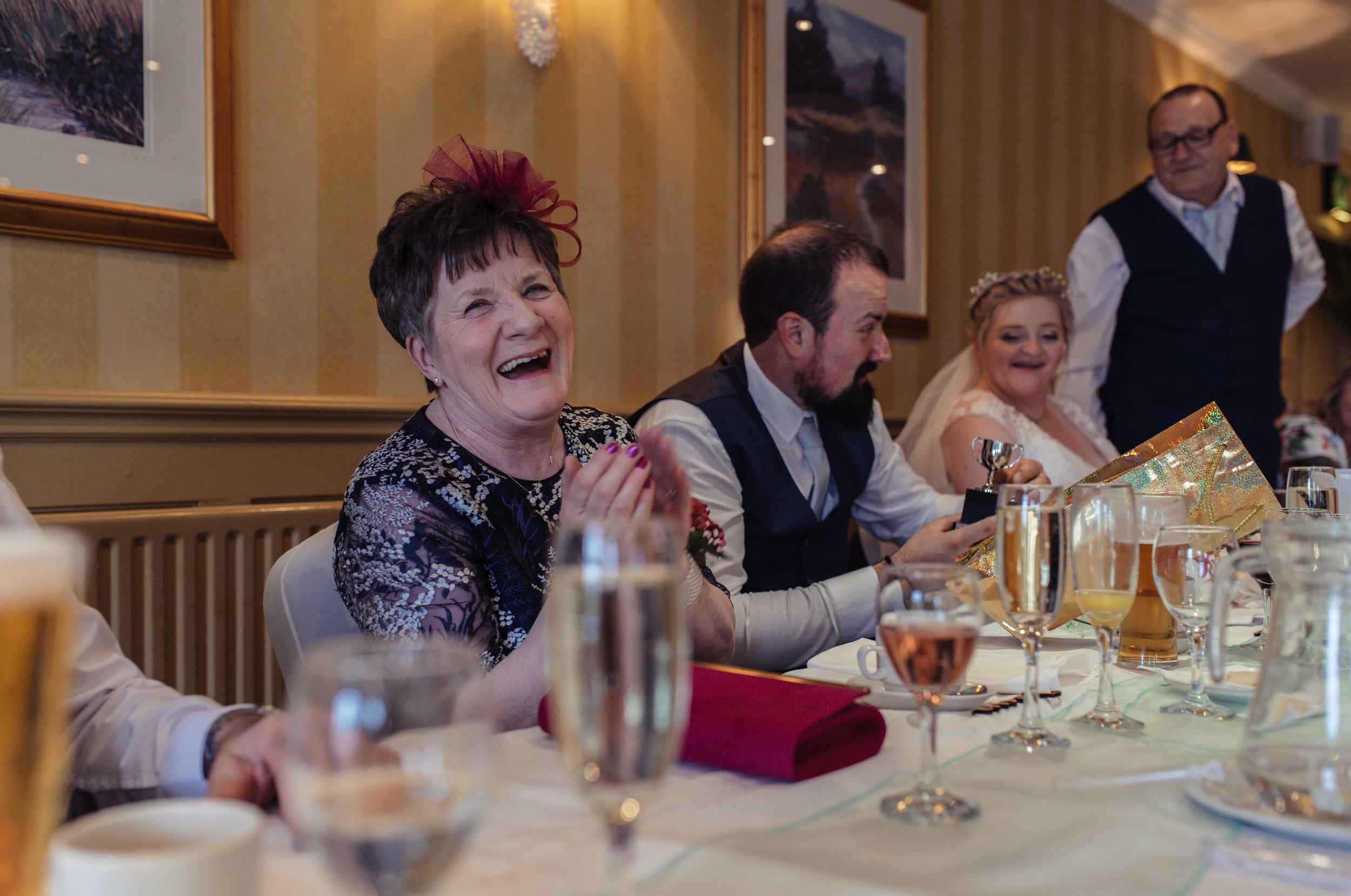 The grooms mother howls laughing during the speeches