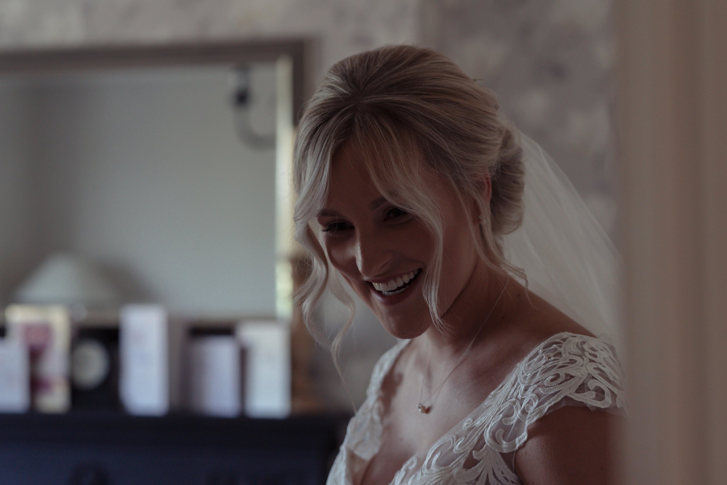 the bride stands in the living room and chats to a flower girl