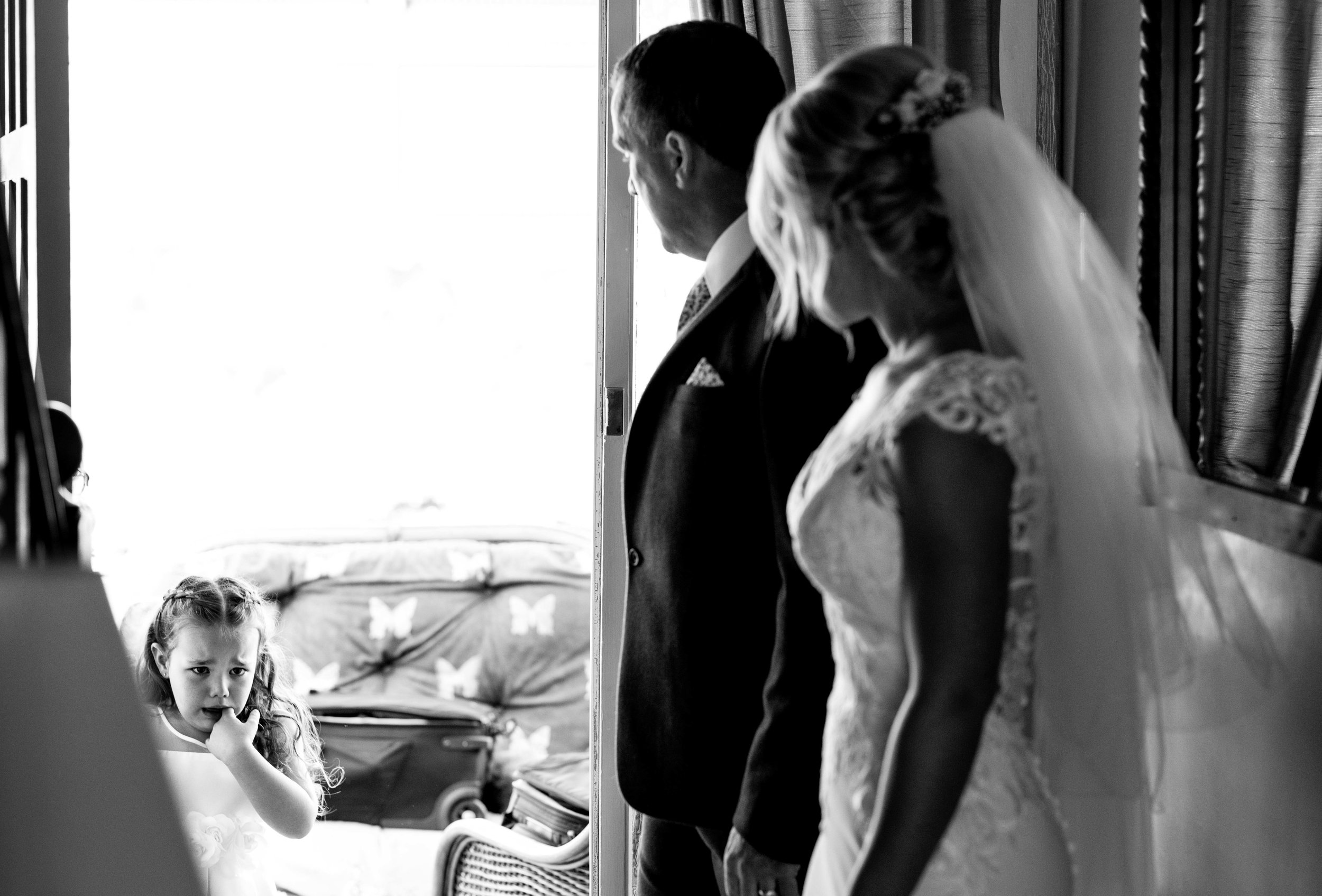 the bride and the father of the bride make the flower girl cry with emotion