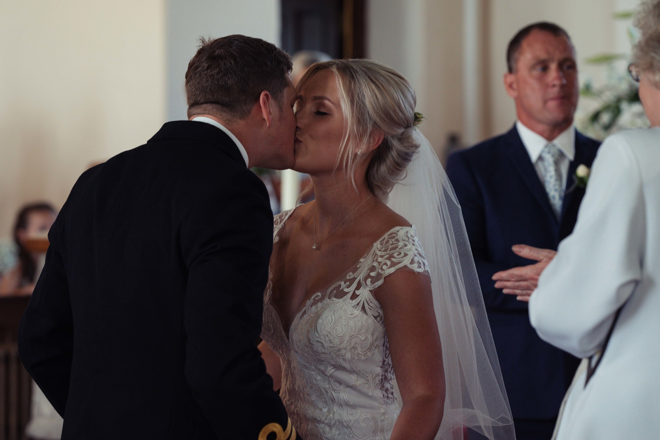 the bride and groom exchange their first kiss as a married couple
