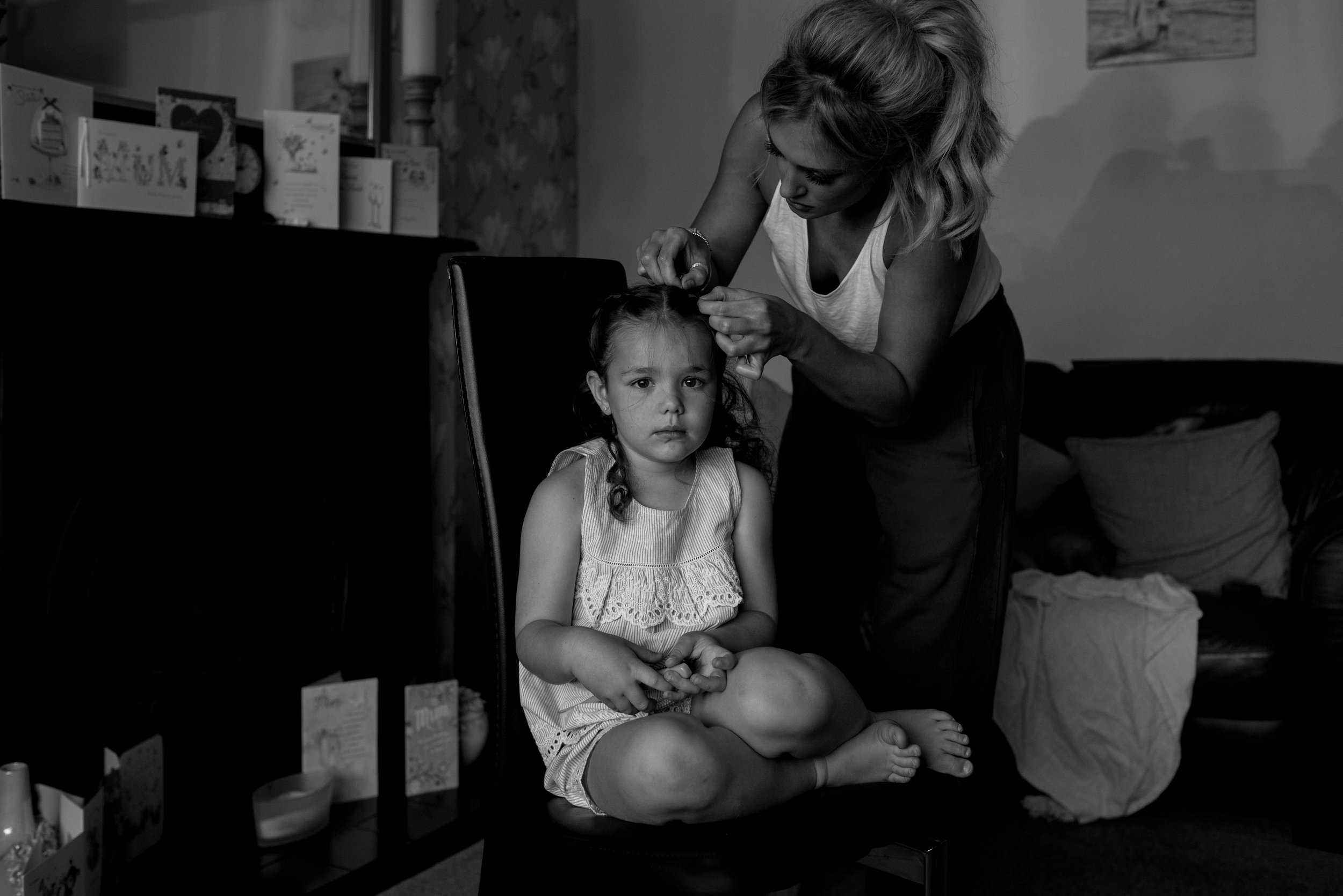 Bridesmaid looks out of the window as she has her hair finished