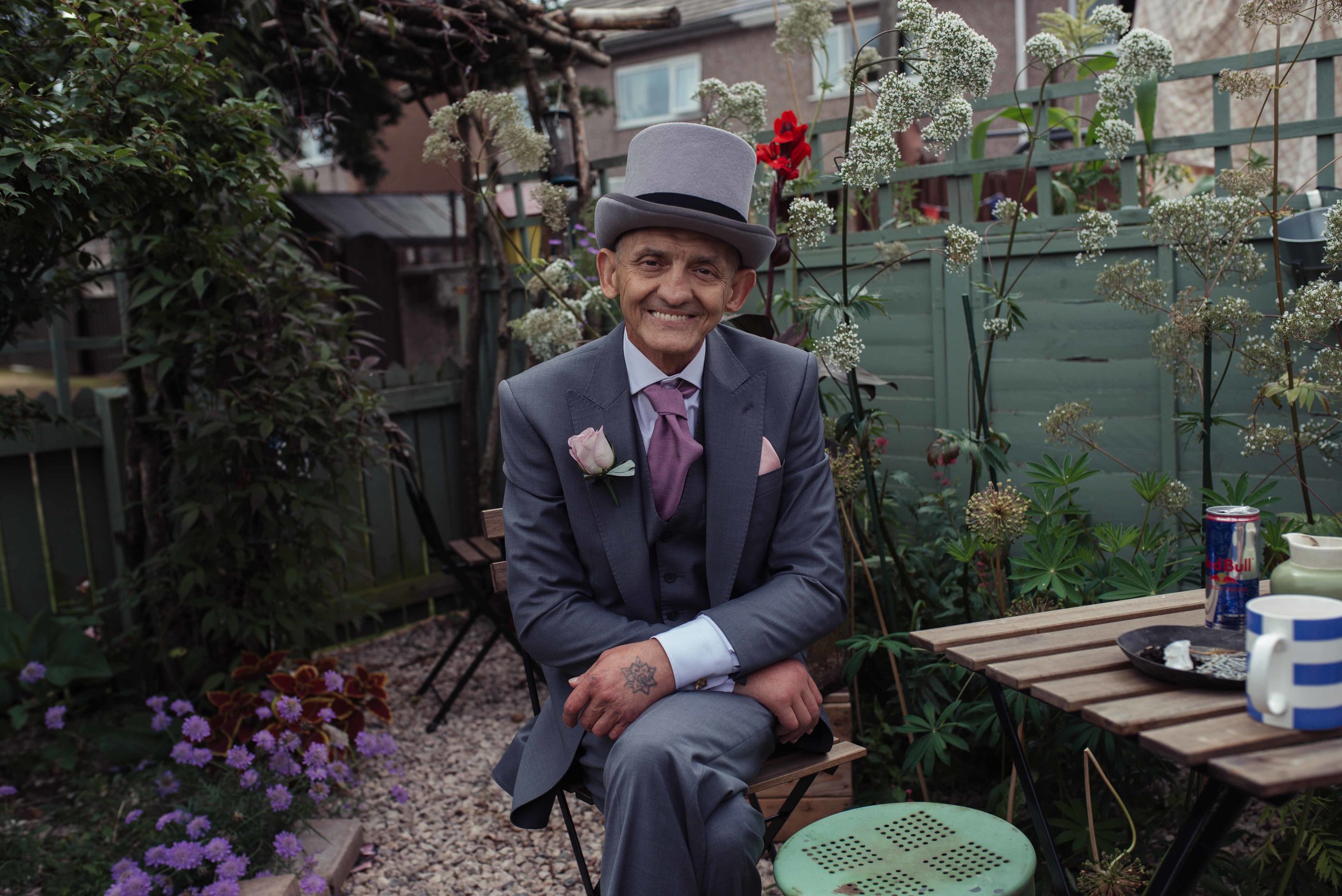 Groom sits posing for a photo in his neighbours garden