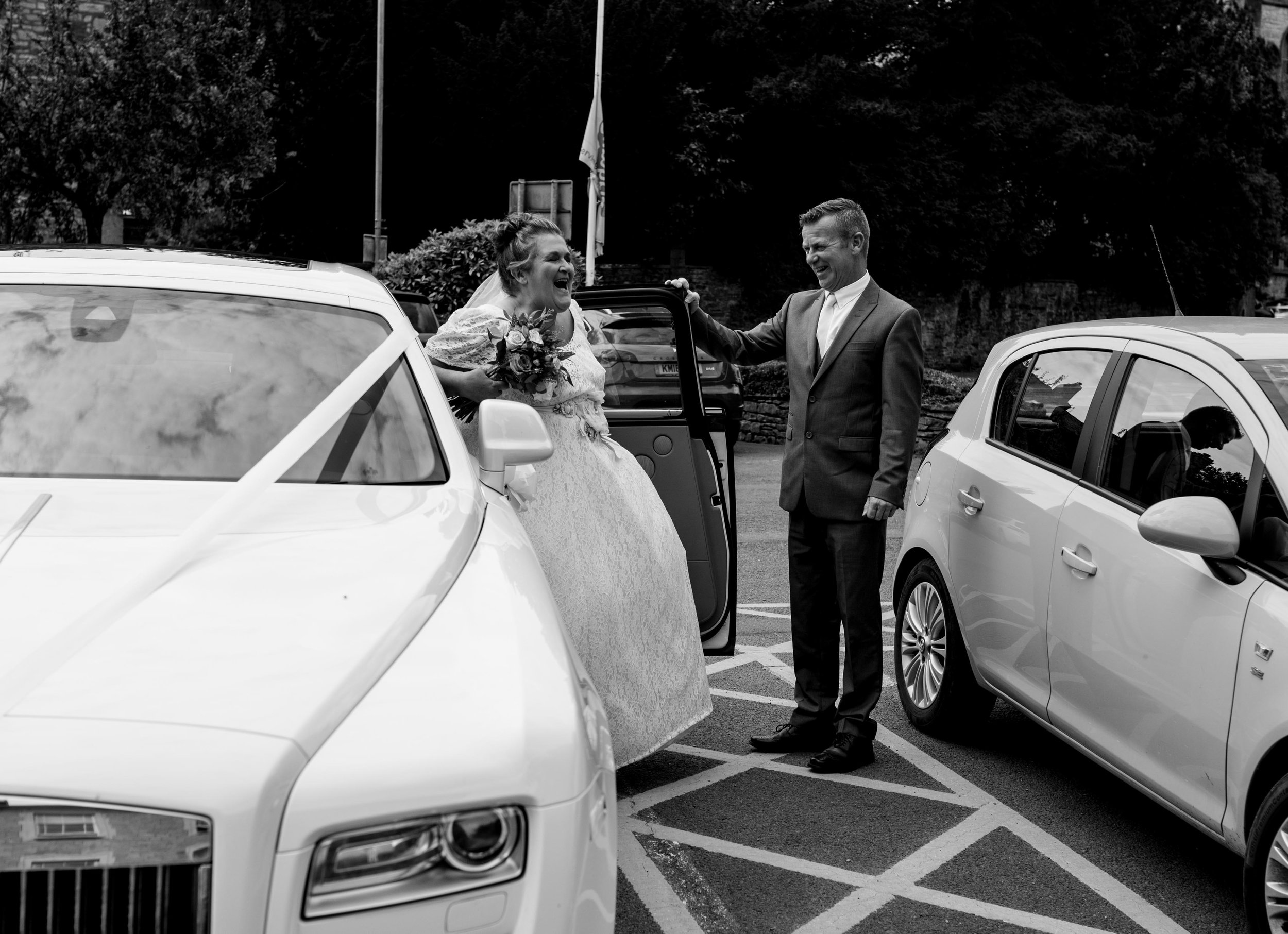 The bride arrives at kendal register office and laughs as she gets out of her white car
