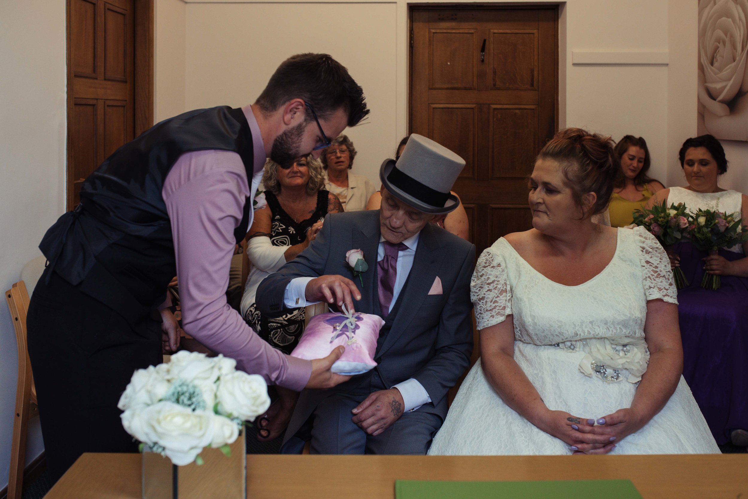 The best man passes the brides ring to the groom