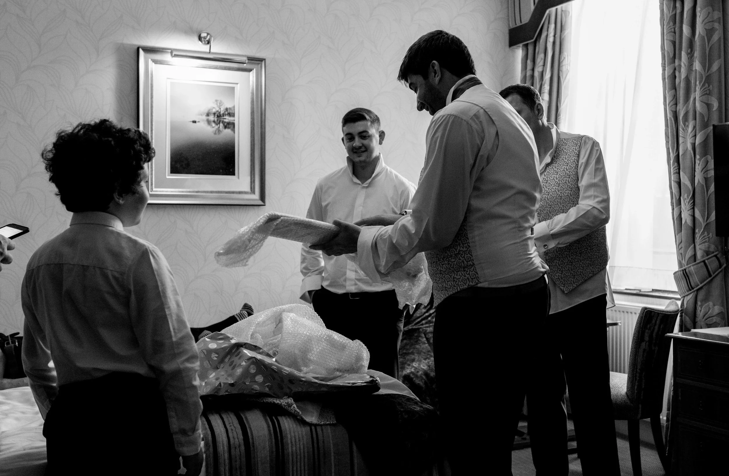The groom opens his presents from the bride