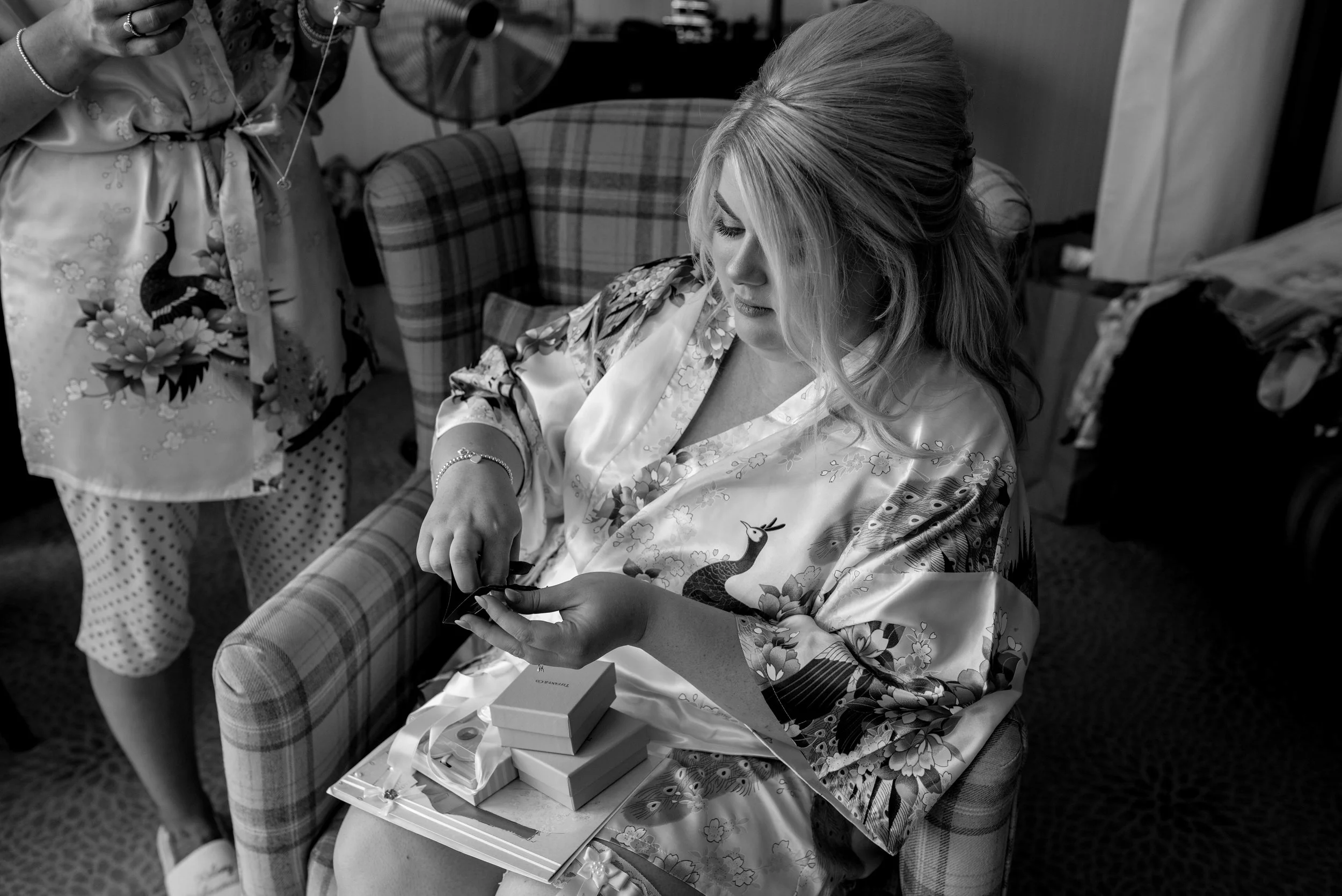 The bride sits and opens her presents off her new groom