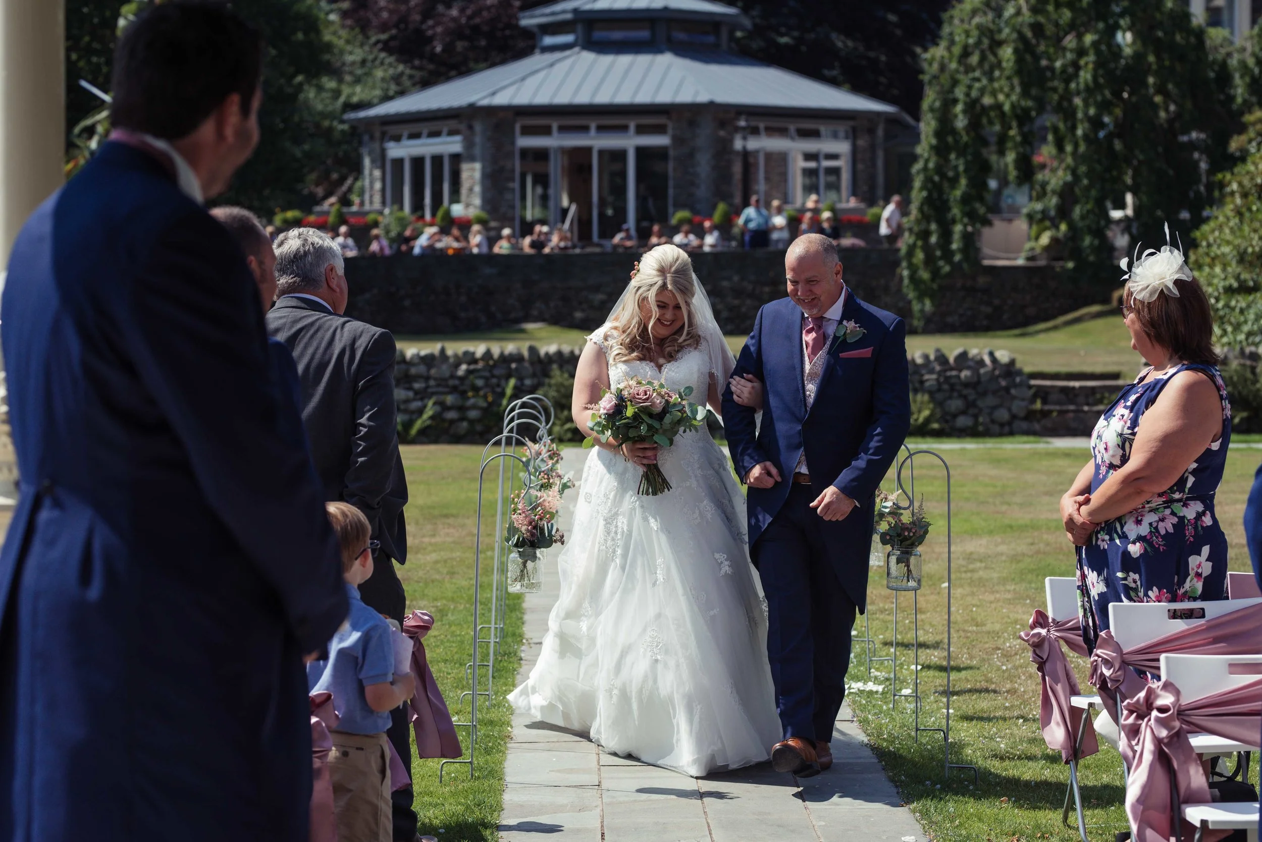 The brides father escorts his daughter down the aisle at the Inn on the Lake