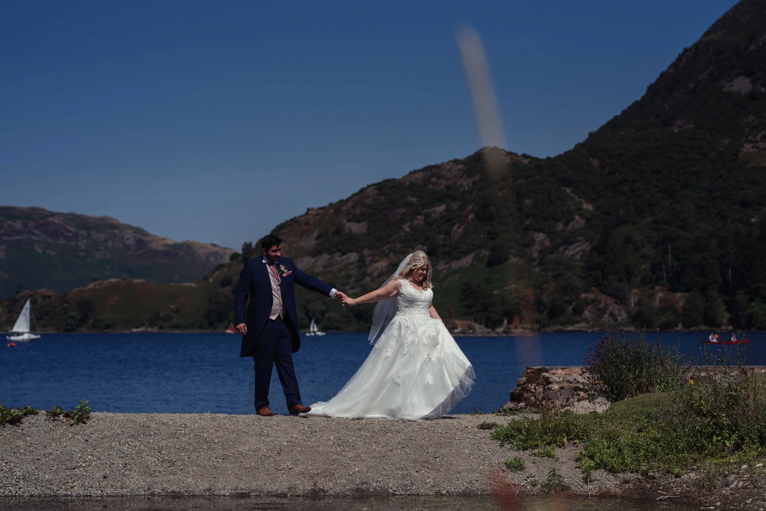 The bride and groom have a walk at the edge of the lake at the inn on the lake