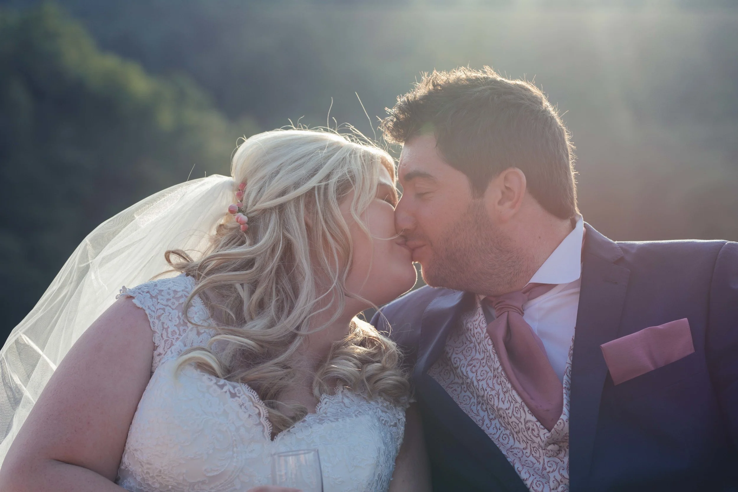 The bride and groom share a kiss together sitting on the boat