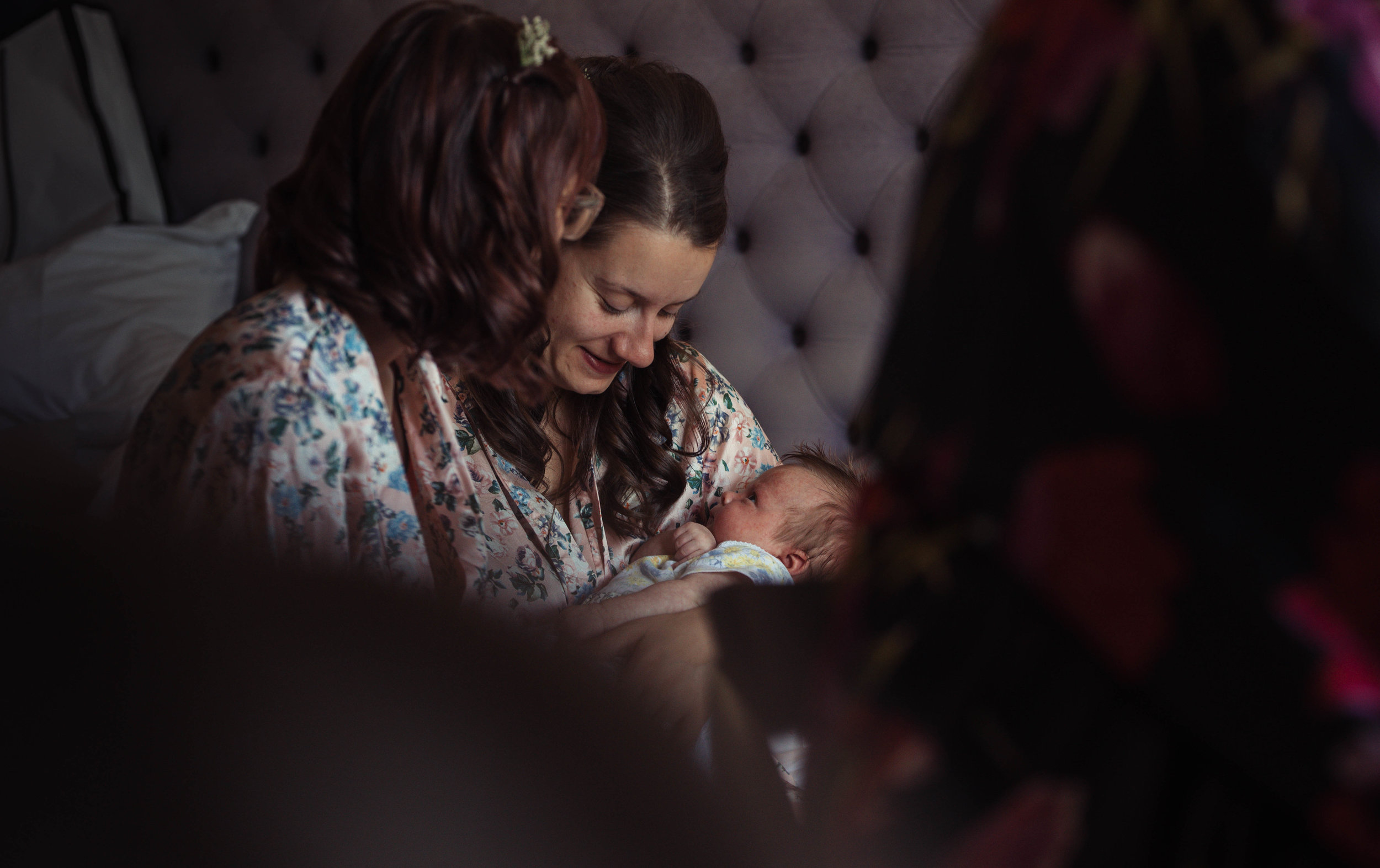 A bridesmaid nurses her baby during the preparations for the wedding