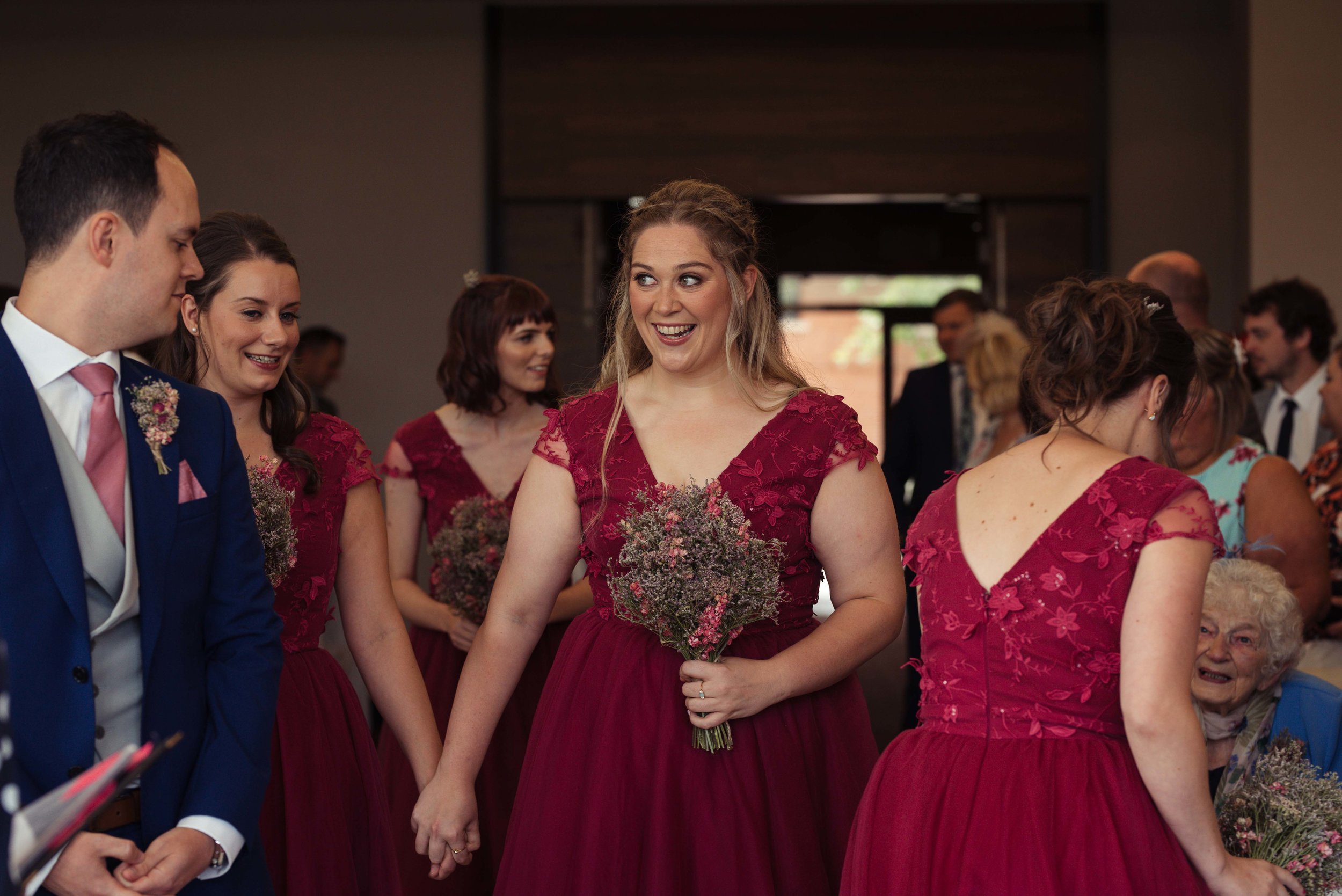 A happy bridesmaid walking up the aisle at the start of the wedding ceremony