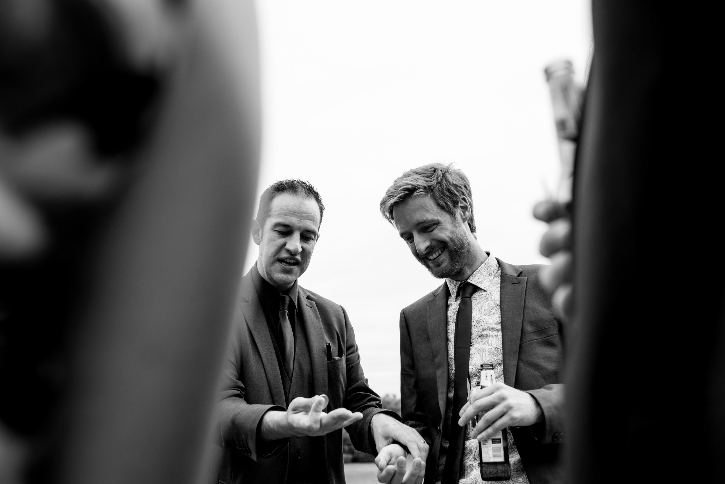 Two male wedding guests having a chat together