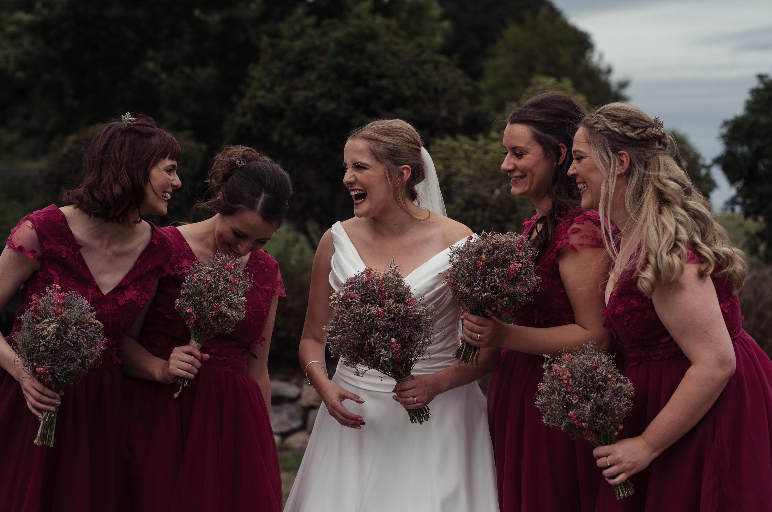 The bride and her bridesmaids having a laugh together during the photo shoot