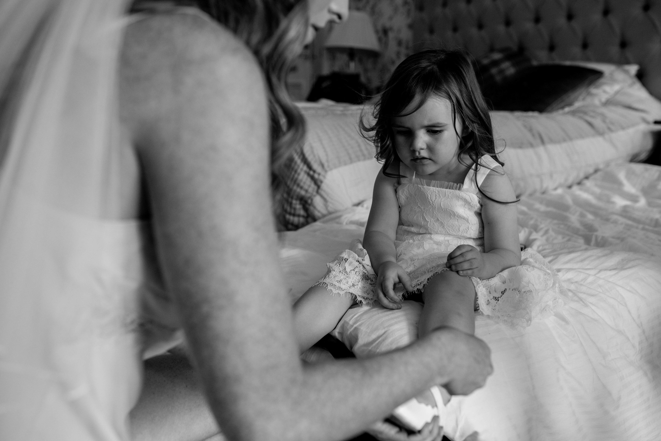 The bride puts her daughters wedding shoes on