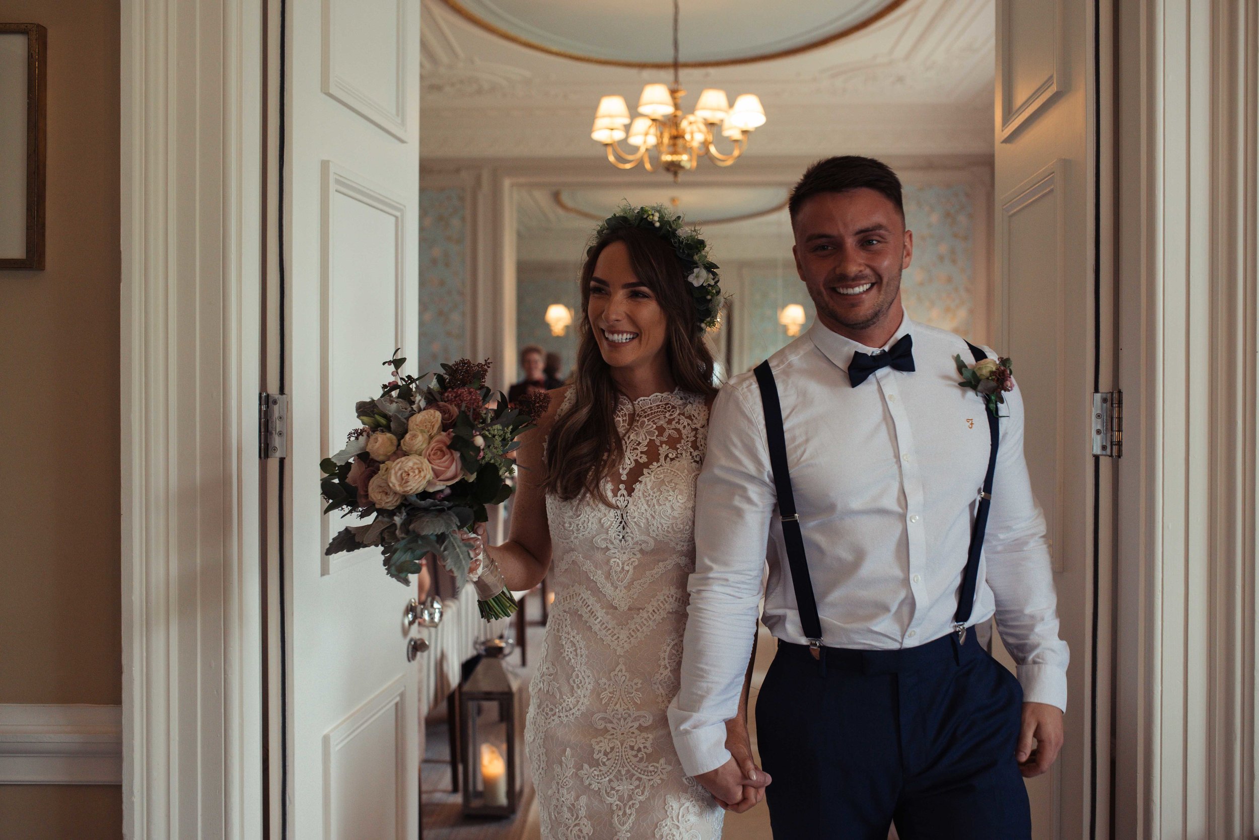 The bride and groom exit their wedding together with big smiles on their faces