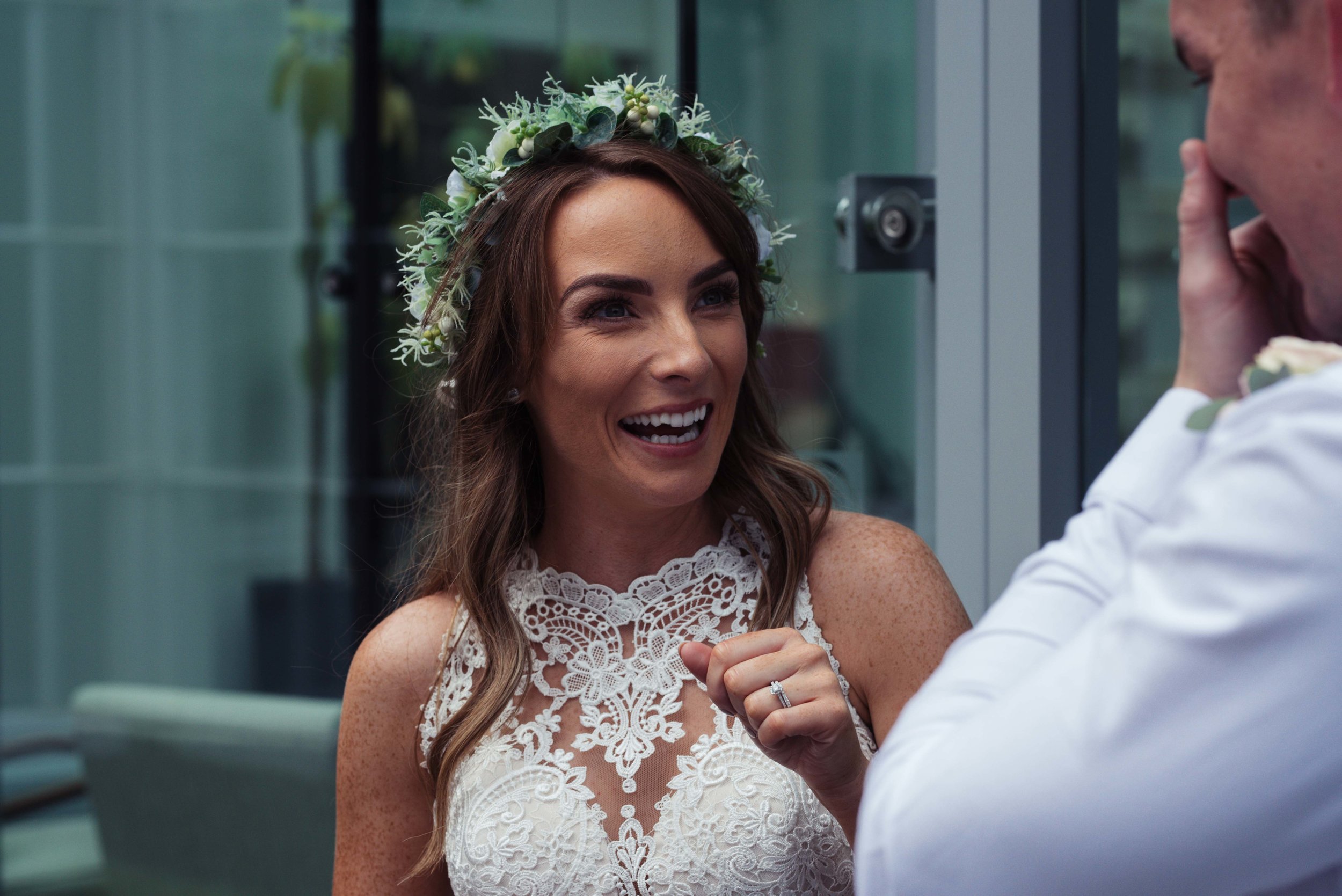 The bride stands outside the belsfield and has a giggle with her brother