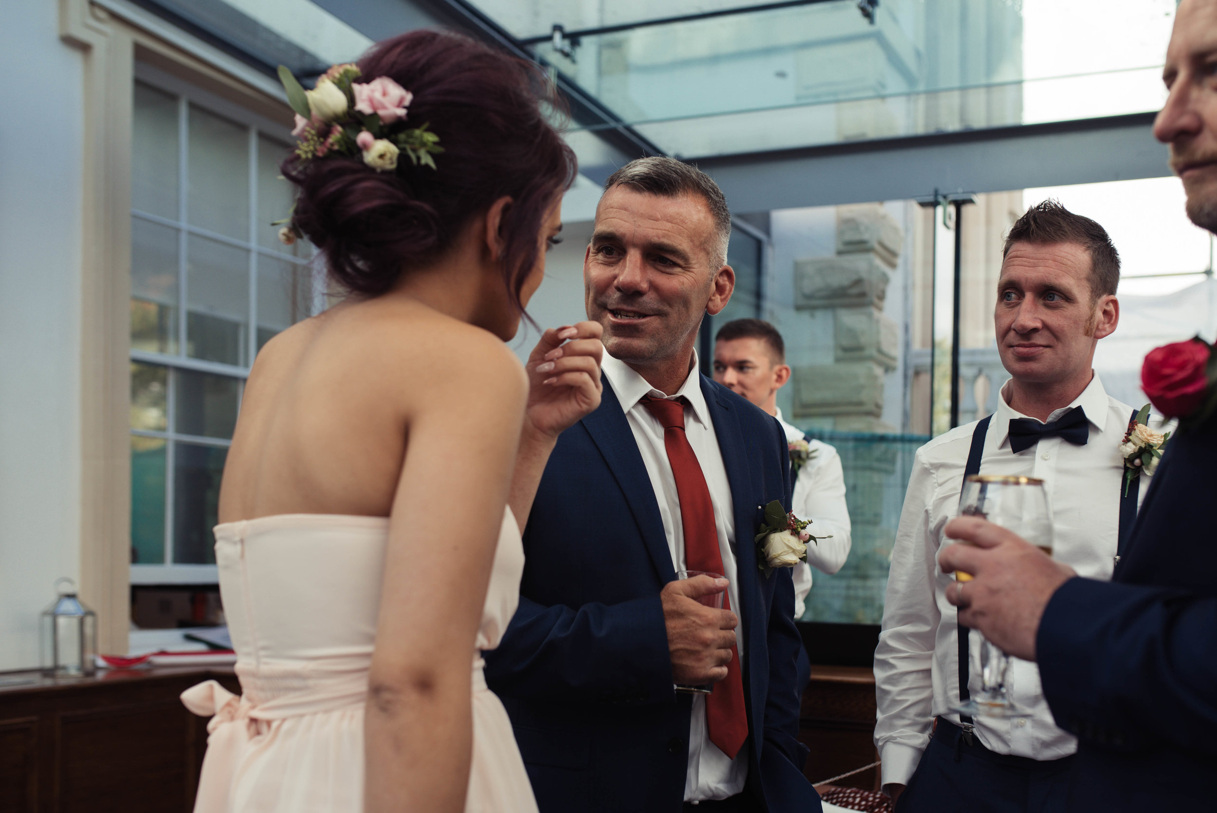 A wedding guest has a cheeky grin at one of the bridesmaids