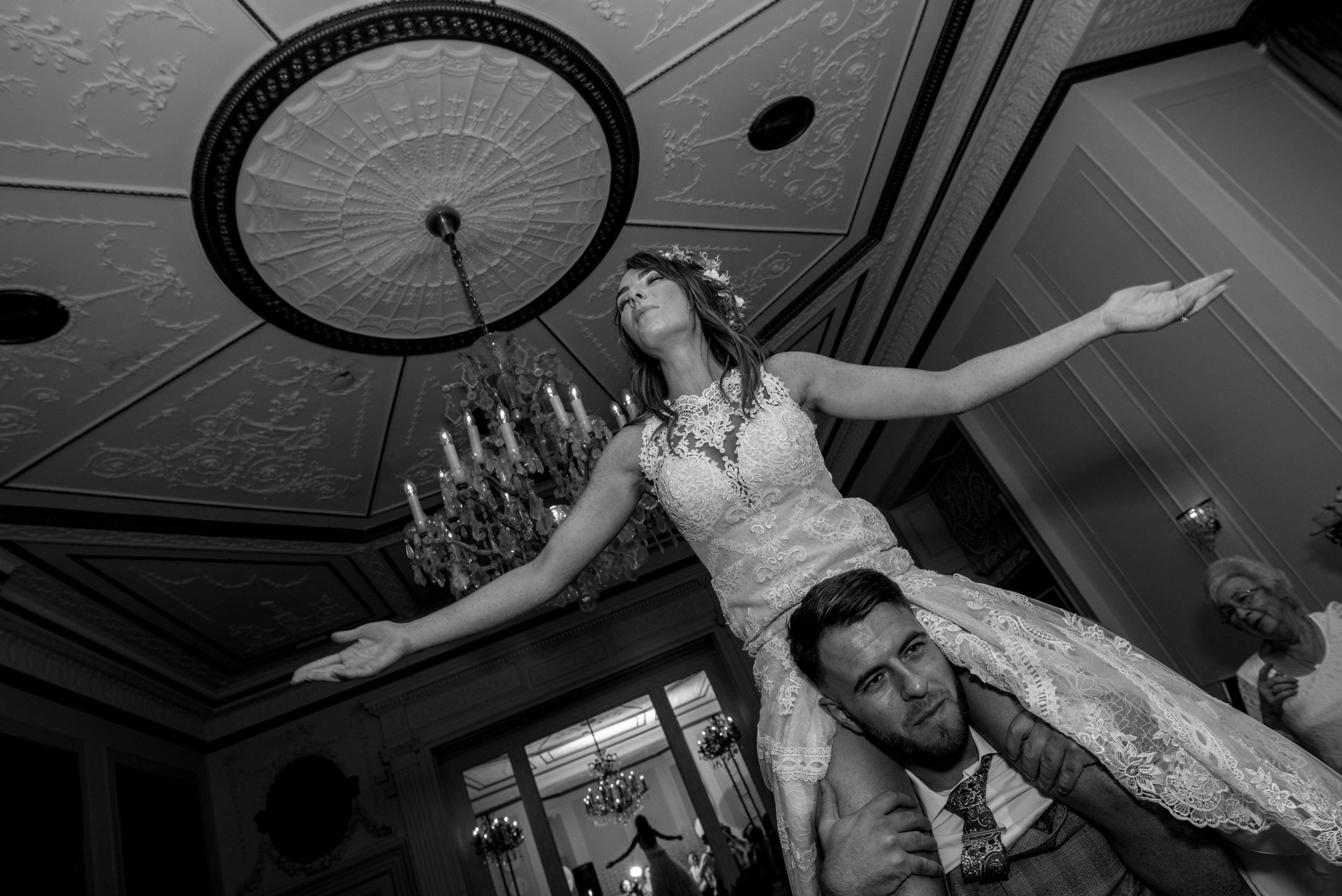 The bride sitting on a guests shoulders