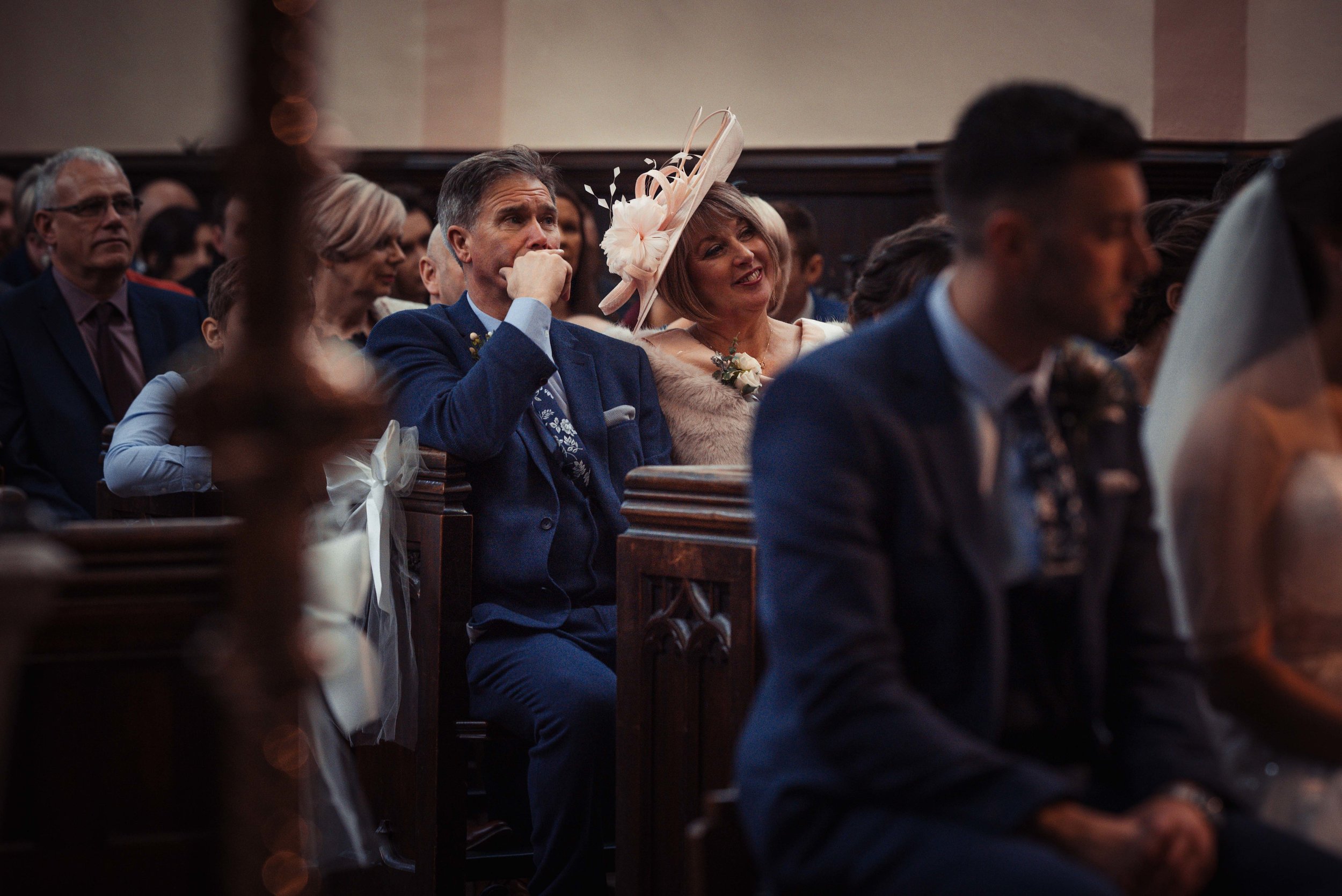 Mother and father of the bride watch the wedding service