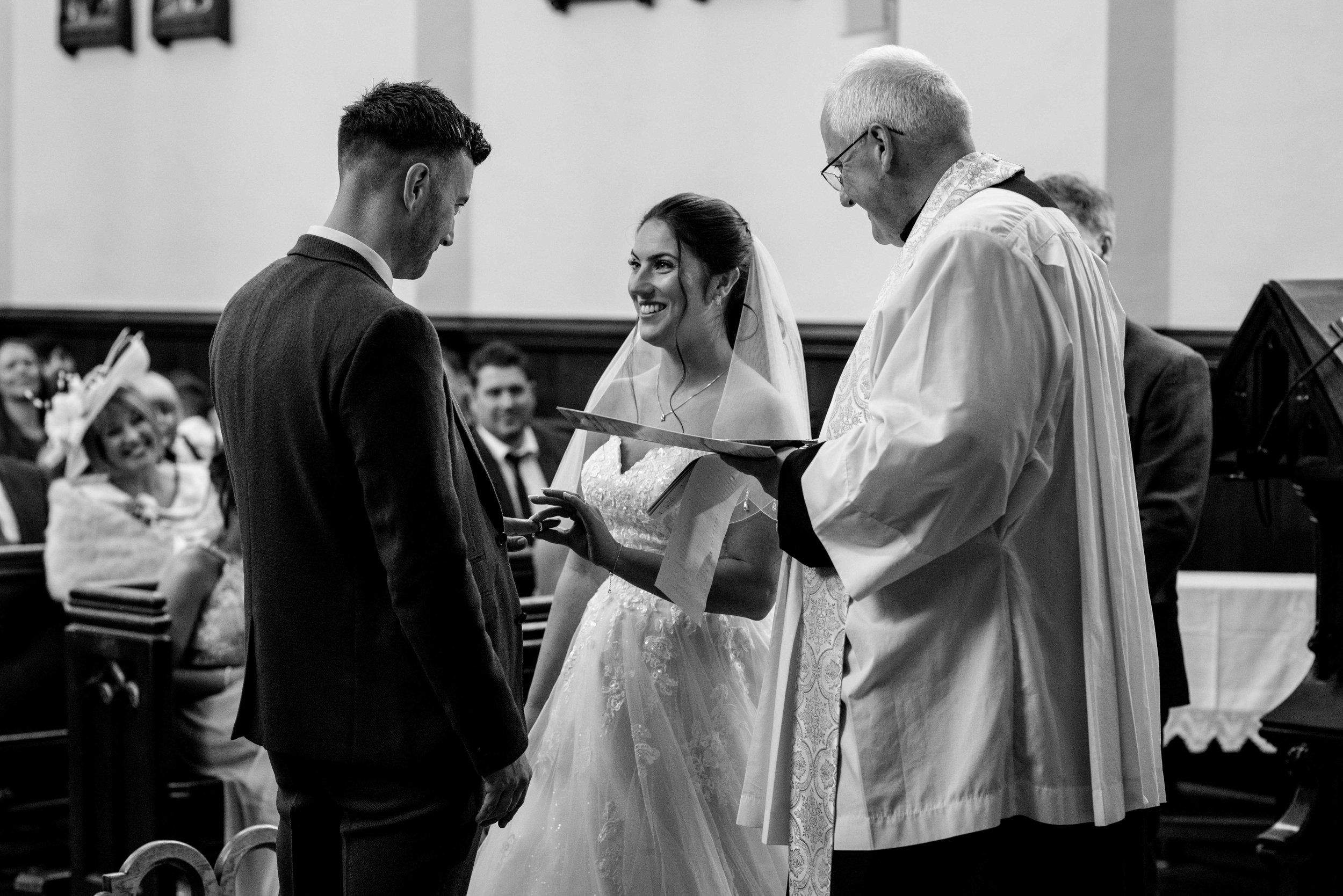 Bride and groom exchange rings during the church wedding service