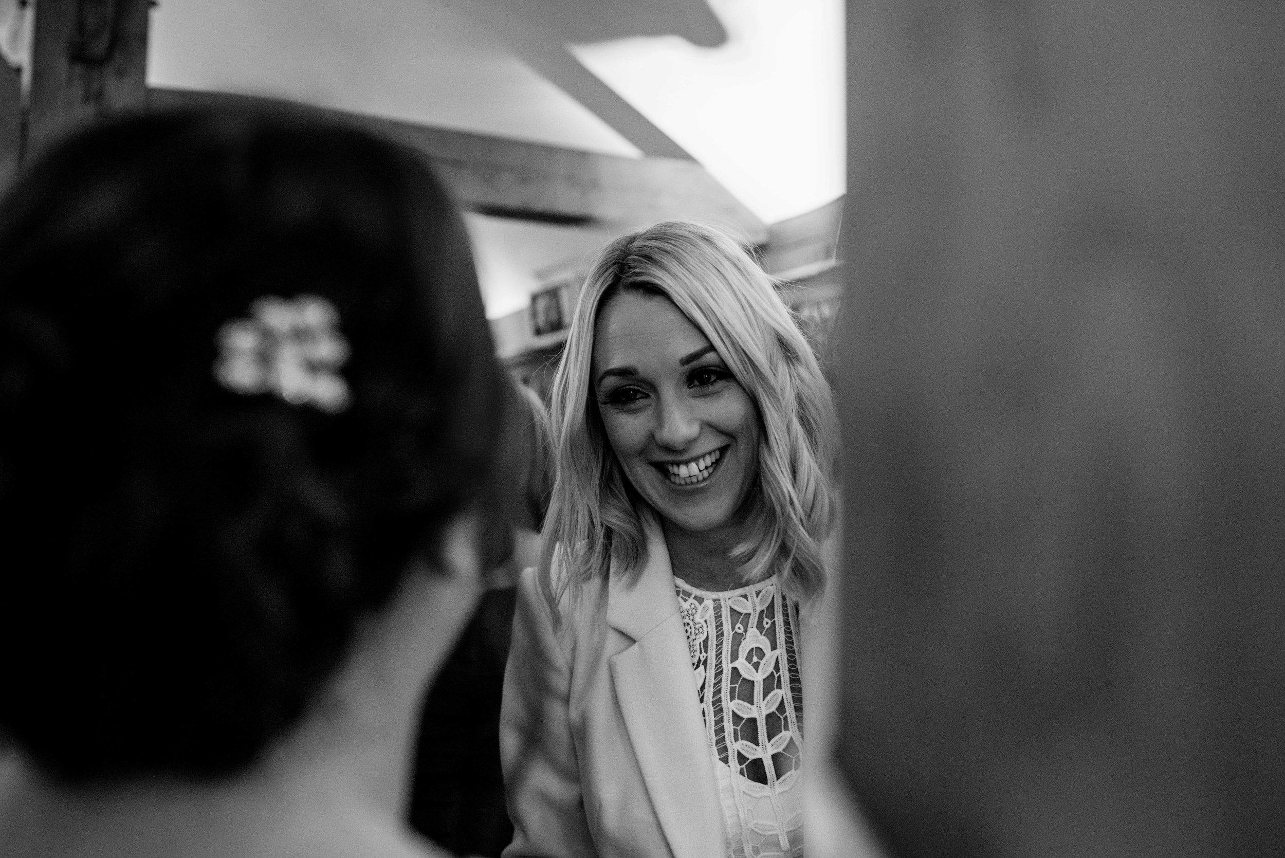 A wedding guest chatting to the bride near the bar