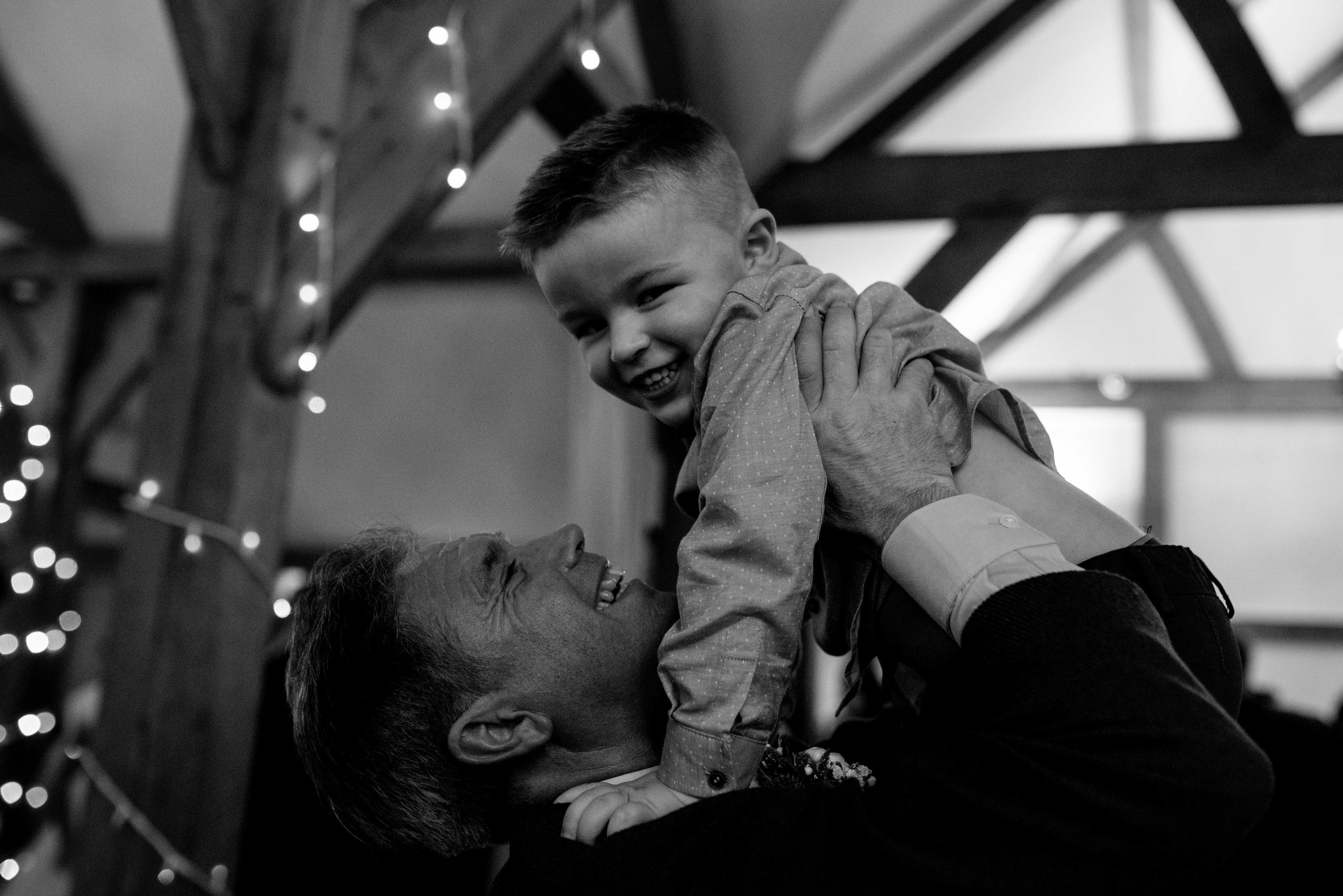 grandfather picks his grandson up and throws him in the air