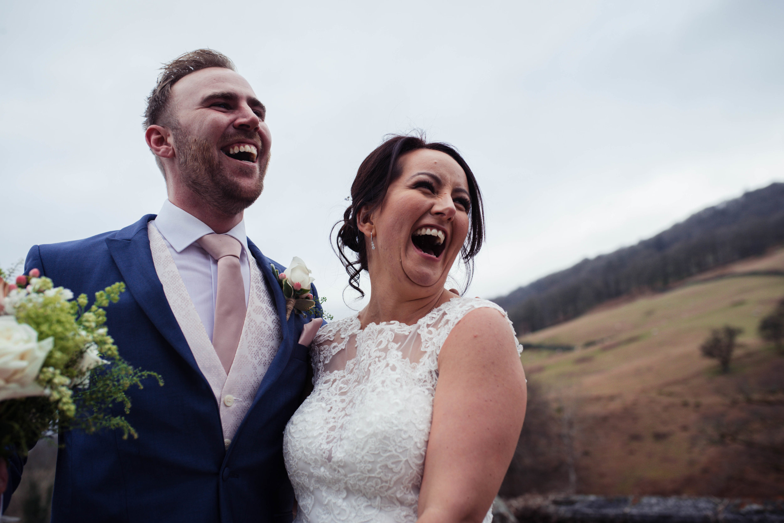 The bride and groom laughing out loud when posing for a guests photo