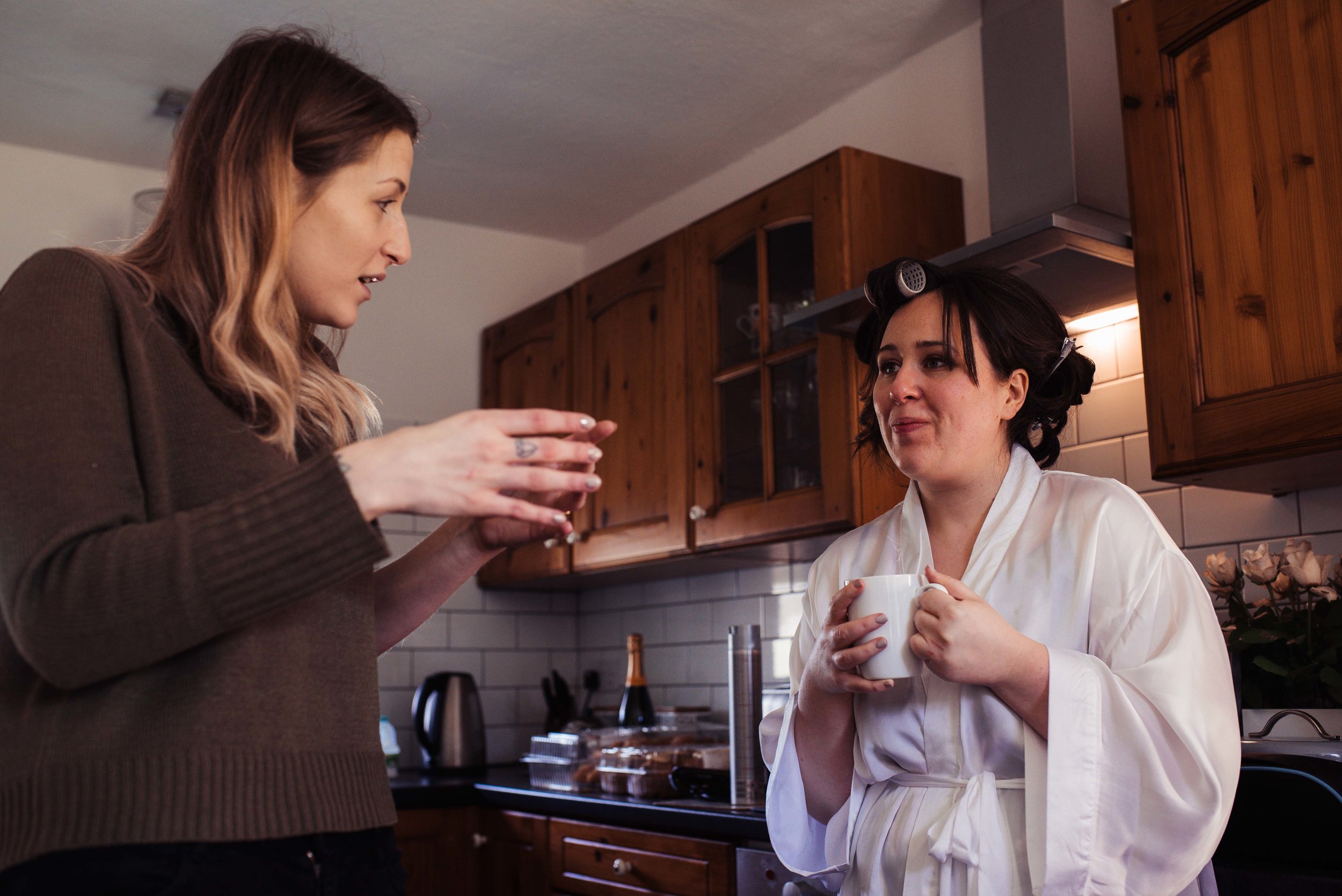 Bride chatting to her maid of honour over a cup of tea