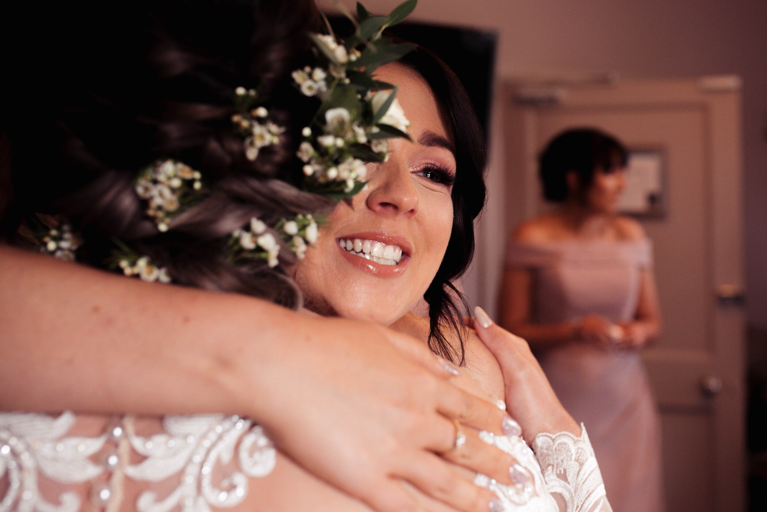 A bridesmaid gives the bride a big cuddle before the wedding