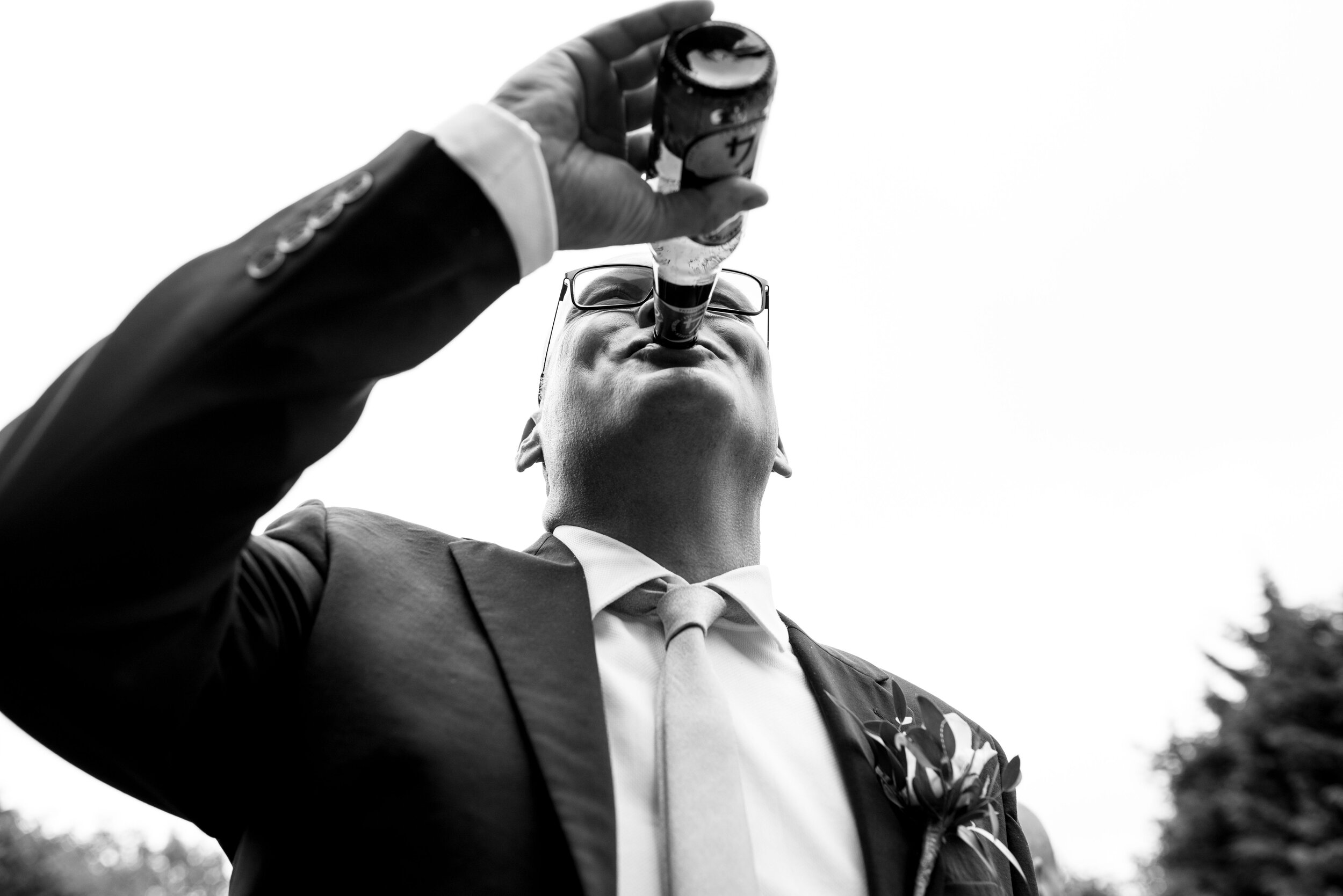 Close up image of a wedding guest drinking his beer