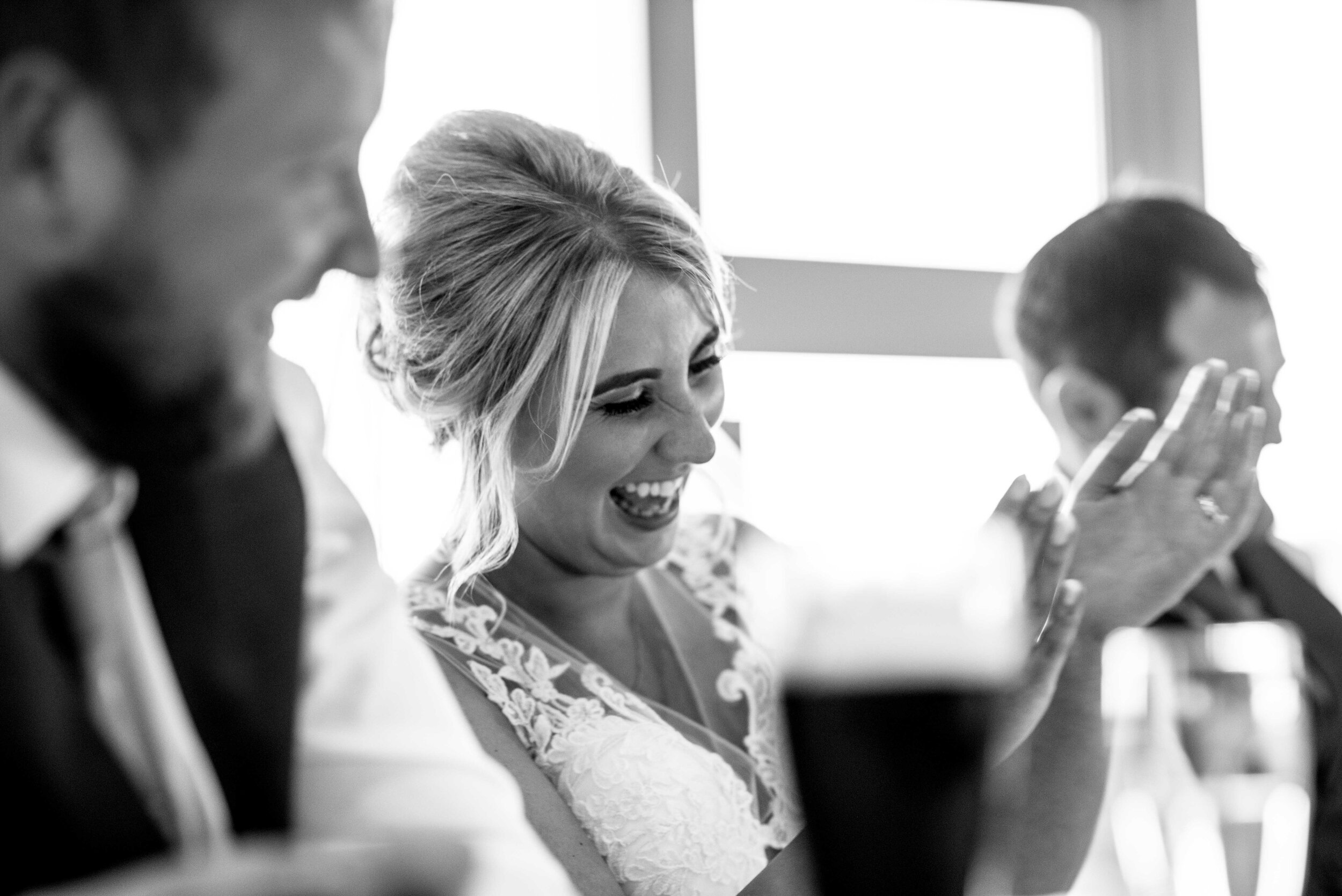 Black and white close up image of the bride laughing during the speeches